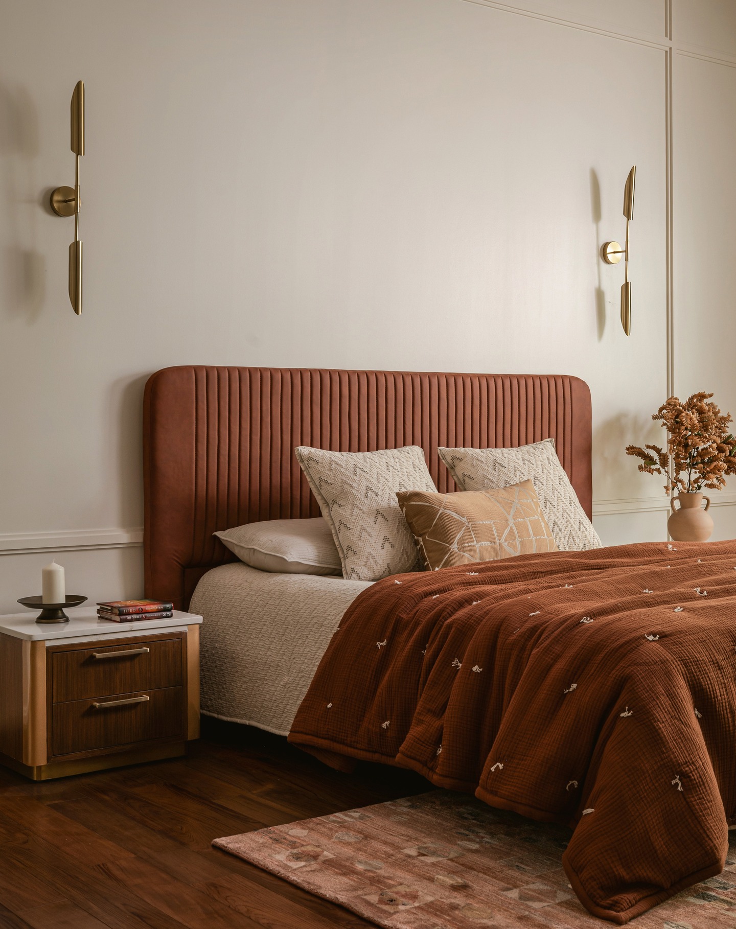 Project Tuzha ~ The Master Bedroom !
The master bedroom blends modern rustic warmth with refined elegance. A cognac , channel-tufted headboard anchors the space, complemented by brass mid-century sconces and soft ivory paneled walls. Layered bedding in earthy tones and textured pillows add depth, while a walnut nightstand and ceramic vase introduce organic touches. A muted rug and dark wood floors ground the room, creating a serene, sophisticated retreat.
Design and execution : Furbishy
Photography : Nayan Soni @nayansoni21
Cinematography: Create Stories @createstories.in
Styling : Shivani Raina @theshalomhome
Rug: @jaipurrugs
Headboard: @thefurnitureco.in