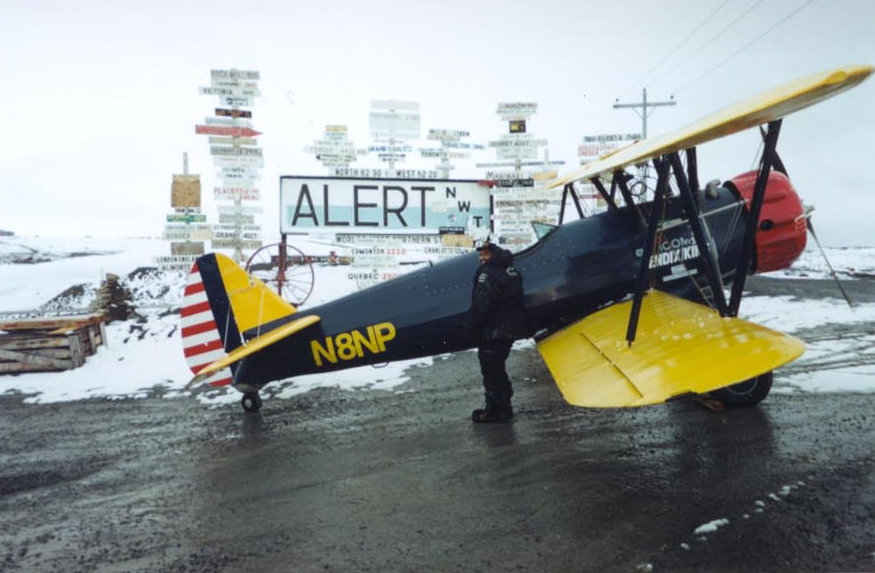 This month in 2000, Gus McLeod became the first person to fly around the geographic North Pole in an open cockpit airplane!
After an intense 13-day journey with multiple dangers and malfunctions, he circled the top of the world three times in victory. McLeod diligently prepared for the grueling journey: he wore a specially-made six-layer parka, gained sixty pounds of “insulation,” and slept with the windows open in winter. You can see his Boeing PT-17 Stearman on display in our museum—with duct tape around the seams to keep the freezing air out!
It was a dangerous trip, and McLeod suffered from frostbite, engine failure, and equipment malfunctions in the freezing temperatures. On his flight home, he had to crash land on a floating sheet of ice called an ice floe.
He had learned to fly at College Park Airport as a university student in D.C. McLeod wanted to be a pilot so badly he made the 7-mile walk—each way!—to the airport twice a week. On September 23, 2000, Gus McLeod flew his Stearman for the last time to land here at College Park Airport.