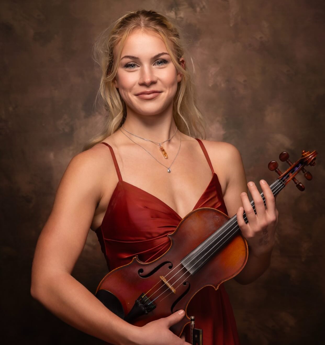 Meet Maggie:
Maggie has been playing the violin since she was 5 years old. It didn’t sound too great at the time, but she’s definitely improved a little bit since then. She comes from a loud, musical family of 13, so music has always been a major part of her life. Between construction work, teaching violin, playing for and singing with Candesca, weight-lifting, and working towards her Level 10 Violin exam, she lives a sweet and happy life.