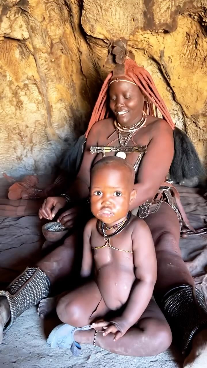 Meet the Himba Tribe of Namibia 🇳🇦
One of the most remarkable Himba traits is that women are not allowed to use water for washing. This implies themselves and also their clothes. According to the elderly, this dates back to the great droughts where water was scarce, and only men were allowed access to water for washing purposes. Apart from applying red ochre on their skin, Himba women do take a daily smoke bath to maintain personal hygiene. They will put some smouldering charcoal into a little bowl of herbs (mostly leaves and little branches of Commiphora trees) and wait for the smoke to ascend.
After that, they will bow over the smoking bowl, and due to the heat, they will start perspiring. For a full-body wash, they cover themselves with a blanket so that the smoke gets trapped underneath the fabric.
MORE INTERESTING FACTS:
The red ochre cream that the Himba are famous for is made by pounding the ochre stone (Hematite) into small pieces. After that, the fragments are mixed with butter, slightly heated using smoke and applied on the skin. After many conversations with the elders of the tribe, I have concluded that the main reason for the red ochre is to establish a difference between men and women. Moreover, the red layer seems to help against the scorching sun radiation, while keeping the skin clean and moist, and to some extent, it blocks hair growth on the body.
On top of the women’s head in the picture, you find the Himba crown: the Erembe. This crown is made of cow or goat leather and is placed on the head when a girl reaches puberty. The red ochre, however, is applied when the girls are old enough to look after themselves hygienically.
Himbas are animists, and their supreme being is called Mukuru. The way they communicate with their God is through the holy fire. The smoke of the holy fire rises towards heaven, which enables them to communicate with their ancestors who stand in direct contact with the Supreme Being.
📍Kaokoland, Namibia
#himba #namibia #travel #travelgram #tribe #africa #travelafrica #travelnamibia #explore #tradition