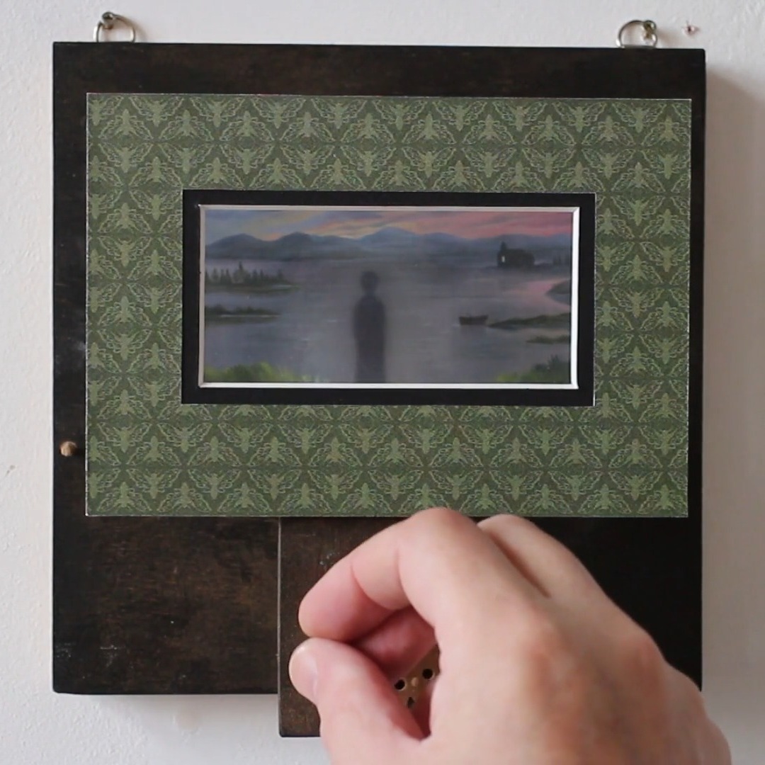 The Rusty Lake Pepper’s Ghost Illusion.
This automaton features a small, hand-painted landscape depicting the lake from the game Rusty Lake.
Using a Pepper’s Ghost illusion, two ghostly figures—The Corrupted Soul and Laura—appear above the scene, adding an eerie element.
The Pepper’s Ghost illusion works by reflecting light off a transparent surface, such as glass or plastic, placed at a specific angle between the viewer and the scene. In this setup, the ghostly images are projected from a hidden space onto the reflective surface, creating the illusion that they are floating in front of the landscape. This technique is often used in theater and haunted houses to produce realistic spectral effects.
In person, the illusion creates a striking 3D effect, making the figures appear as if they are truly hovering in front of the background.
The Pepper’s Ghost technique typically relies on lighting the ghostly figures, but in this case, a dark apparition—The Corrupted Soul—can also be seen. This raises the question of how this figure appears without being illuminated. But the lake does not reveal all its secrets!
