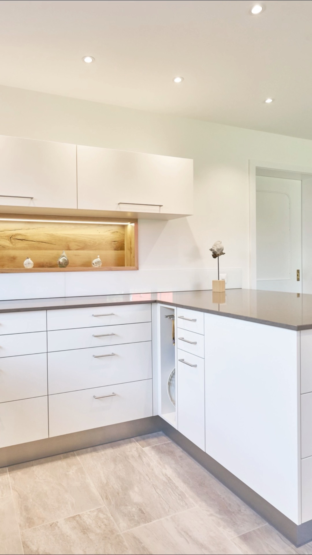 ✨ Klare Linien, helle Fronten und ein Hauch Natur. 🌿 Diese Küche verbindet modernes Design mit warmen Akzenten aus Holz – vom edlen Massivholztisch bis zur beleuchteten Nische. Lieblingsplatz-Garantie inklusive. 💛