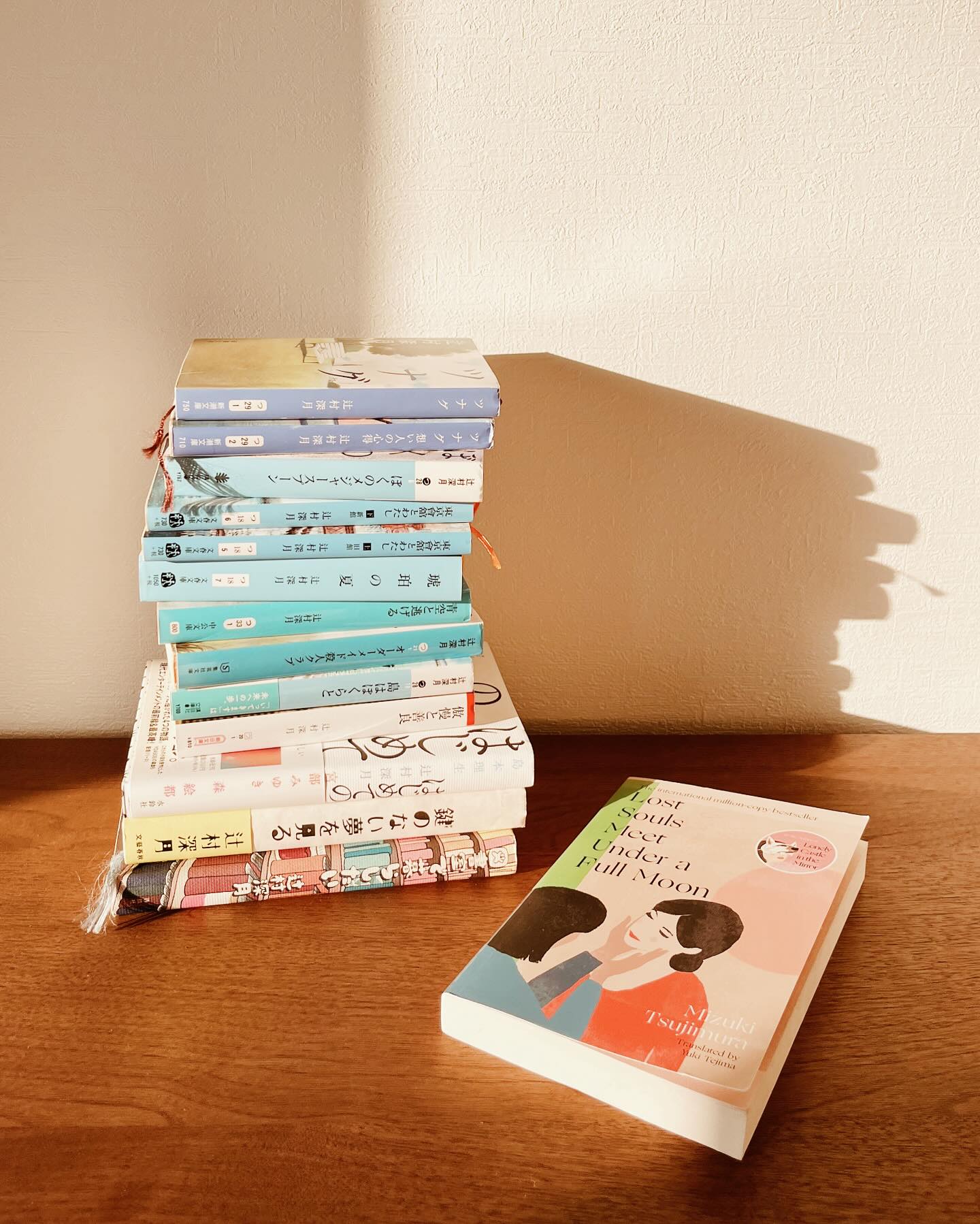 It means so much to see and hear many of you reading Mizuki Tsujimura’s LOST SOULS MEET UNDER A FULL MOON. Thank you.
So you know the third narrative in the novel, about Misono and Arashi? And how it’s a bit brutal compared to the ones before it? There’s a reason for that.
I love the story the author tells about writing that chapter (it is documented in what is essentially a Mizuki Tsujimura encyclopedia that I own) and how she had the deadline wrong…by a MONTH. I shudder as I type that…
(The stories were originally published as a series in a literary magazine before it became a book in 2010, which is why they begin as episodes…though that later changes, of course.)
She had just finished a different piece of writing and was taking a breather, eating ice cream, when her editor emailed and said, “I didn’t receive your piece today, so I will look forward to it next week.”
At this point, the author knew only that the story would be about two high school friends, but she hadn’t thought further than that. Desperately, she says, she focused every bit of energy she had and wrote that story in TWO DAYS. Initially she’d imagined a gentler, feel-good ending, but what she ended up with was…right.
And the editor loved it.
I loved learning this, because one, Mizuki Tsujimura is human! Just like one of us! (Except that she then wrote that chapter in two days.) And two, that’s why, when translating the story, I felt myself disappearing into those girls - Arashi and Misono - aching for them.
Thanks for reading, and thanks to my best friend in LA who heads her LA high school’s theater department, and who I ran all those theater terms by! I was picturing my best friend and her students rehearsing in their auditorium as I translated. I don’t know that she’s ever read Japanese literature before, so I was thrilled when she said she loved the book 💓
Don’t know why I shared that today - seeing your posts and stories are moving to me, is what I wanted to say. 🙏🏻✨
(Pictured also - some of my other Tsujimura books that make up maybe a quarter, if that, of all she has written in Japan)