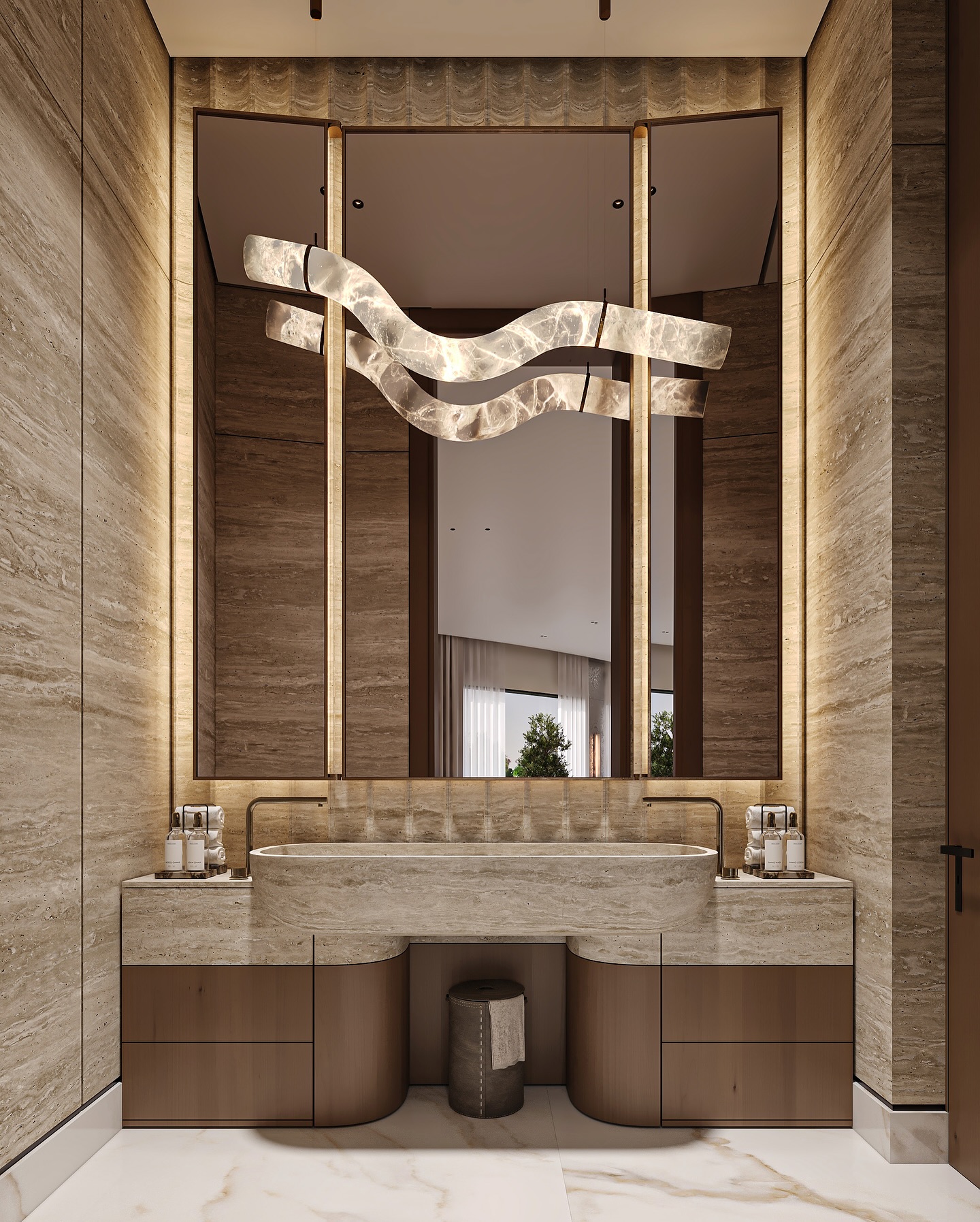 This powder room by Maroon Architects in Irqah, Riyadh, exudes luxury and warmth through the use of beige travertine stone and rich walnut wood cabinetry ✨.
A sculptural travertine basin and custom vanity create a refined focal point, enhanced by brushed bronze fixtures and elegant detailing 🛁.
The statement alabaster chandelier and backlit mirrors provide soft, ambient lighting that elevates the entire space 💡.
Polished marble-look porcelain flooring ties the design together with timeless sophistication 🏛️.