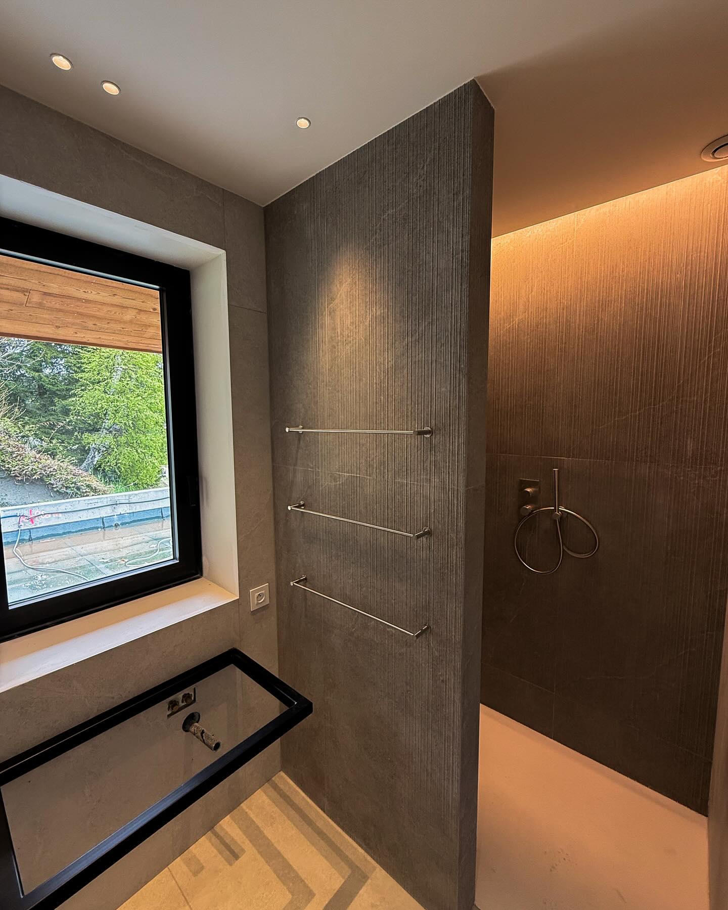 Découvrez un intérieur où chaque détail compte. De l’escalier rétroéclairé aux lignes épurées jusqu’à la salle de bain sobre et raffinée, tout a été pensé pour allier design et fonctionnalité.
Escaliers : Lignes nettes et éclairage LED intégré pour un effet chic et sécuritaire.
Toilettes : Une ambiance feutrée et minimaliste, avec un éclairage ciblé pour une touche d’intimité.
Douche : Jeux de textures entre murs sombres rainurés et surfaces claires, accentués par un éclairage indirect élégant.
Un bel exemple de comment le design peut transformer les espaces du quotidien en lieux d’exception.