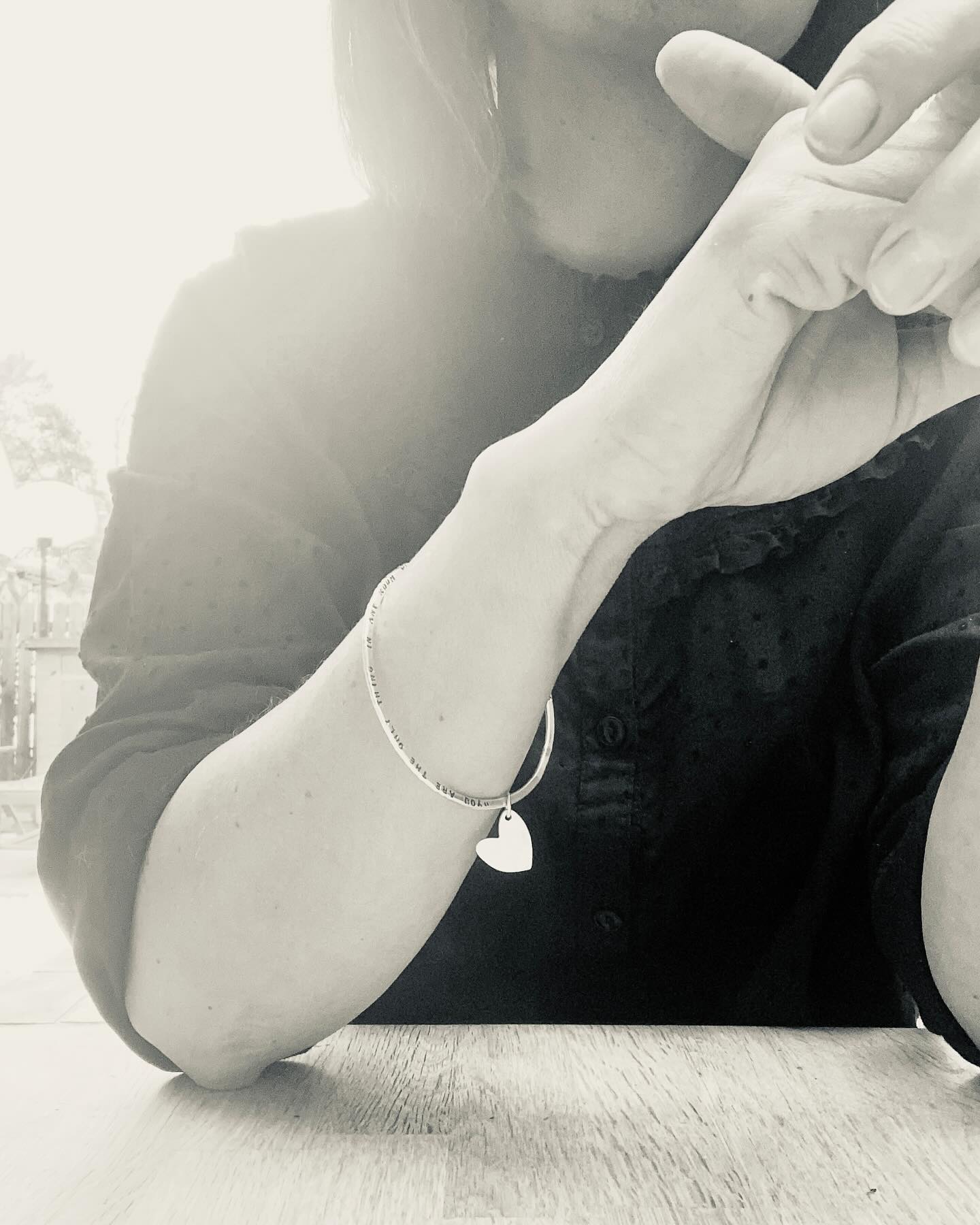 I’M NEW HERE 💕
This beautiful Sterling Silver bangle can be personalised to carry your own special words...
We don’t engrave your wording, every single letter is hand stamped, giving you a totally one-of-a-kind piece of jewellery.
Your handmade Silver bangle carries a single heart charm, crafted from Pure Silver, which measures approx 15mm, and swings freely.
If you have a little bit more to say, there is the option to personalise both sides of this bangle...perhaps you’ll choose to stamp your favourite lyrics, your children’s names, coordinates or your wedding vows...
The round bangle is squashed flat until a thickness of around 1.5mm. It’s a nice and slinky (but sturdy) piece - PERFECT for stacking.
#magicinthegrass #handmadejewellery #personalisedgift #giftsformums #somethingspecial #silverjewellery #banglelove