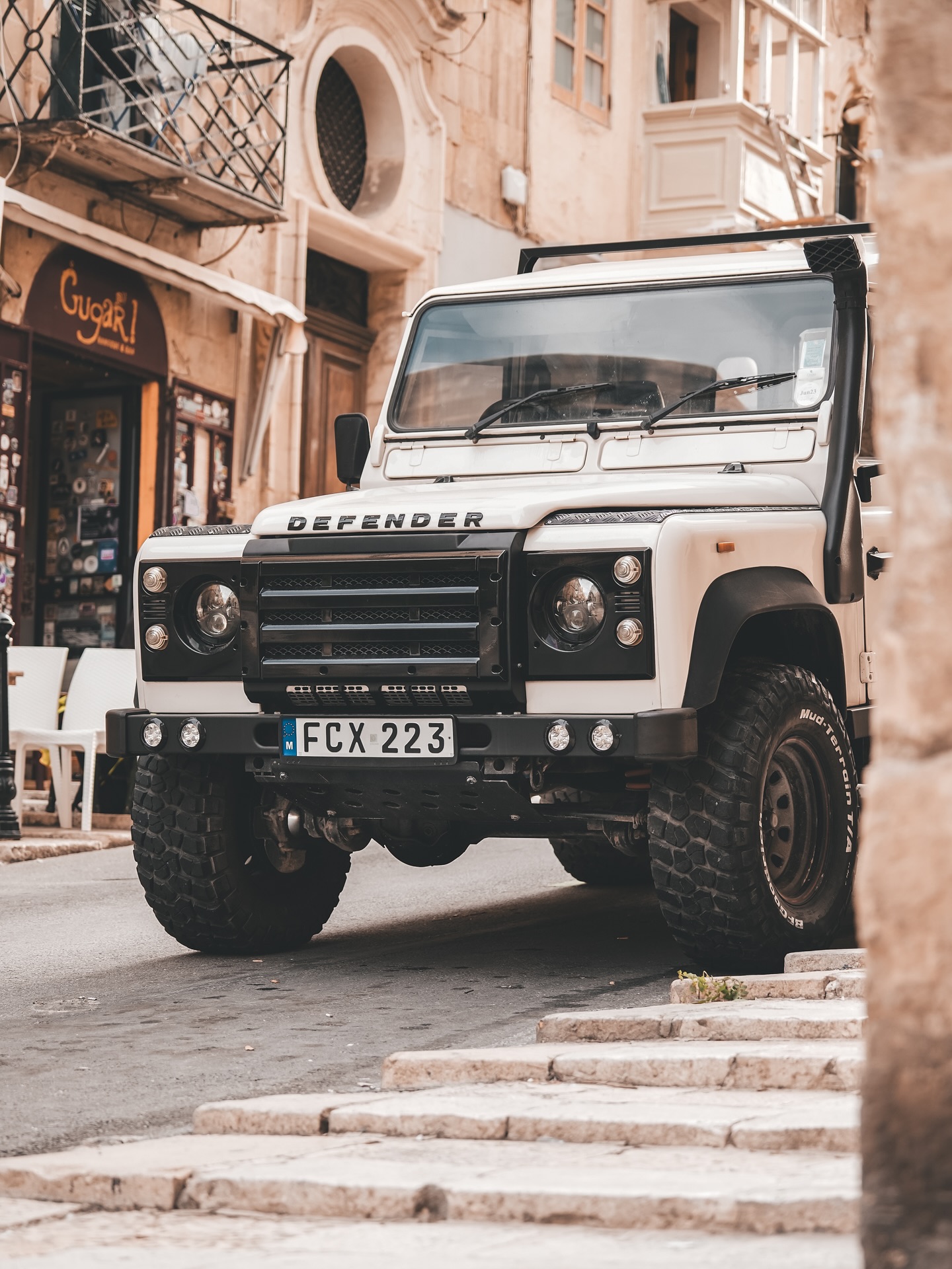 Valletta, diese kleine, wunderbare Hauptstadt auf Malta, wirkt auf den ersten Blick wie ein Museum. Aber sobald Ihr Euch in die Gassen verirrt, merkt Ihr schnell: Hier pulsiert das echte Leben.
Die Straßen sind so schmal, dass man manchmal das Gefühl hat, sie wurden für Gespräche von Fenster zu Fenster gebaut. Und genau das passiert auch. Alte Damen hängen ihre Wäsche raus und winken dem Nachbarn gegenüber. Katzen liegen faul auf den warmen Steinstufen. Und irgendwo läuft immer jemand mit einer Einkaufstasche und einem Espresso in der Hand durchs Bild.
Was mich an Valletta am meisten fasziniert hat: Jede Straße hat ihren eigenen Rhythmus. Die eine ist still, mit moosbewachsenen Fassaden und nur dem Geräusch von Möwen. Die nächste ist laut, voller Stimmen, knatternder Motorroller und Musik aus einem offenen Fenster.
Diese Stadt hat Patina. Kein perfektes Postkartenidyll, sondern Ecken und Kanten. Überall bröckelt ein bisschen Farbe von den Holzbalkonen, irgendwo quietscht eine alte Tür, und der nächste Laden um die Ecke verkauft seit 50 Jahren genau dasselbe.
Wenn Ihr hier unterwegs seid, geht langsam. Lasst Google Maps in der Tasche und folgt einfach der Neugier. Setzt Euch auf eine Stufe, schaut Euch um, hört zu. Valletta zeigt sich nicht in einem Moment, sondern in vielen kleinen.
Mein Tipp: Früh morgens losziehen, wenn die Sonne die Gassen noch schräg trifft und die Schatten länger sind. Dann ist Valletta am ehrlichsten.
#valletta #malta #gassenliebe #altstadtflair #vallettastreets #citydetails #reiseblogger #stadtspaziergang #vallettaphotography #malta🇲🇹 #mediterranegefühle #vallettavibes #gassenglück #stadtmomente #urbanvibes #reiseinspiration #unterwegsaufmalta #fokusfernweh #reisegefühle #stadtliebe