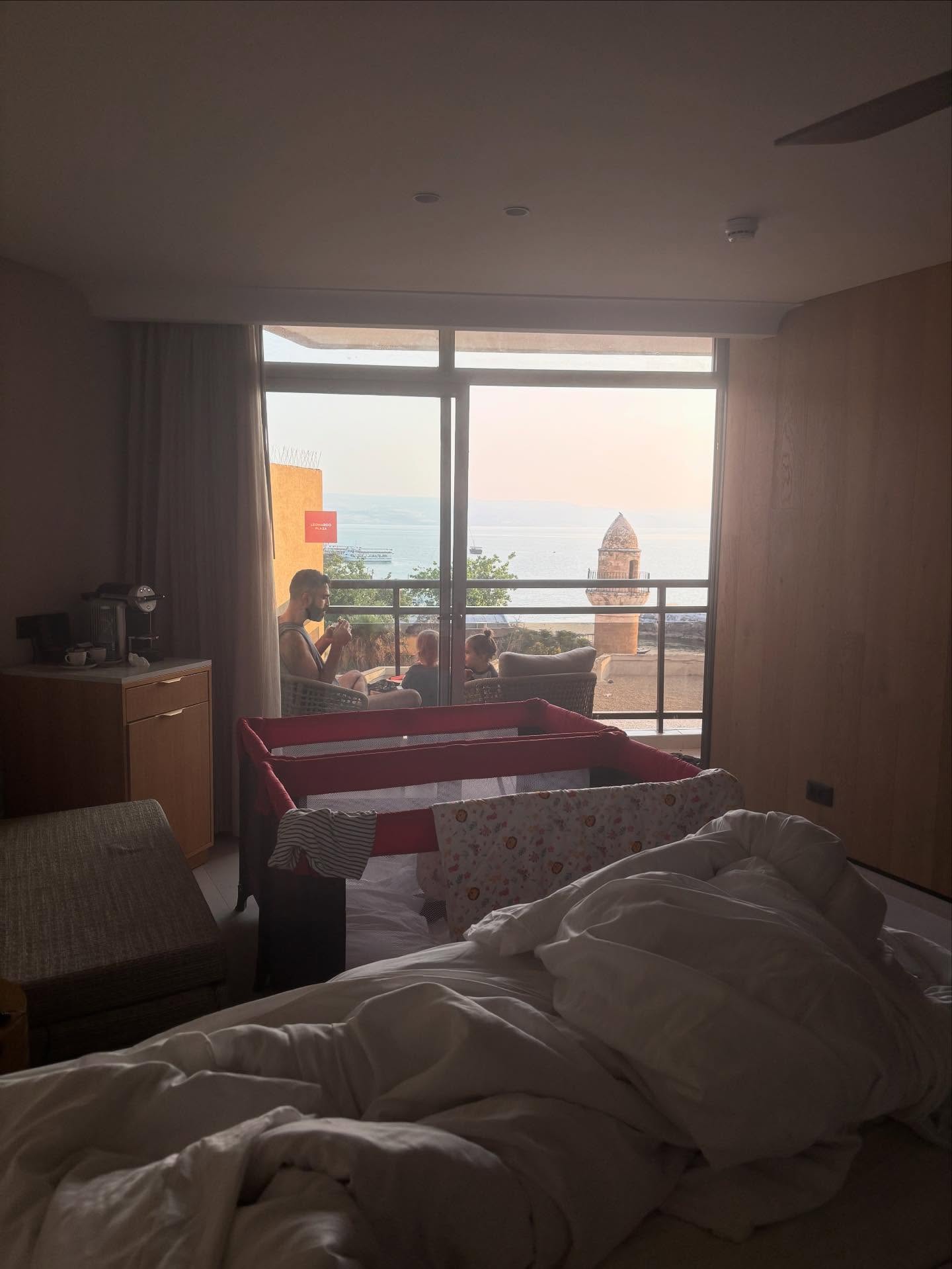 יש מקום בלב שלי ששמור לכנרת ולטבריה.
כבר כמה ימים שאני מכין את יובל לנסיעה ספונטנית
ובשישי בבוקר ישבנו להזמין לילה אחד במלון (שהיה מוצלח!)
ומתאים לילדים, במרחק נסיעה של שעה וחצי מהבית.
בריכה, כנרת, שמש, ים
וצריח של מסגד בנוף של החלון.
חוויה משפחתית מאחדת, רק של התא הקטן שלנו.
ביום השני לחופשה בבוקר
בחדר האוכל,
בעודי הולך להביא עוד גבינה צהובה לאסיף
ובמקביל רני צועק מרחוק ״אבא! אבא! אבי! אבי!״
ליד עמדת הגבינות אני שומע קול אחר שמתקרב אליי
״אני לא מאמינה שאני רואה אותך פה, אני לא מאמינה!״
אני מסתובב לכיוון הקול המוכר הזה, מזהה חברת אמת מגיל הנעורים
ושנינו מתחבקים את החיבוק של החיים.
ומשם התחברו אליה ואל הבנות שלה
והתא הקטן שלנו הפך להיות
חבורה מורחבת בבריכה.
ניצלנו את שפת הבריכה
לצמצם פערים
אני על החיים שלה
היא על החיים שלי
שאלנו
התעניינו
ראיתי בעיניים לראשונה את האמא שהיא
והיא ראתה לראשונה את האבות שאנחנו
ראיתי אמא חזקה עם לב ענק.
בשיחה סיפרה לי
כמה אבא של הבנות כלל לא בתמונה
החל מגירושים לתוך התרופפות הקשר
ואיך היא רואה על הבנות את החוסר.
היא מספרת
כשהוא כן מגיע ופוגש אותן הדבר שהן הכי רוצות הוא שירים אותן
חייכתי חצי חיוך
כמה להרים ילד זה לא רק פיזי
אלא ממש חווית בטחון, עוצמה וכייף.
דבר שכל אבא יכול לעשות!
בעצם לא כל אבא.
יש אבות שלא מסוגלים ״להרים את הילדים שלהם״ מהרבה סיבות
יש כאלה שמרגישים לא ראויים להיות אבא
שלא מאמינים באמת ביכולת שלהם להיות דמות שנותנת בטחון, חוסן, עוצמה וכייף
שלא מאמינים בזה שהם יכולים להיות אהובים וקשורים
שלא מאמינים שהם יכולים להיות עבור מישהו אחר יחד עם הצרות והבעיות שלהם
שלא מאמינים שהם יכולים ליצור קשר עם הילדים כשהם לרוב מעדיפים את אמא
שלא מאמינים שהם יכולים להיות קודם כל עבור הילדים שלהם.
השיחה על שפה בריכה הייתה כמו אגרוף לבטן
שאלתי את עצמי, כמה ילדים כאלה עוד מסתובבים בעולמנו עם החוסר הזה?
ונשארים עם הבור
שמתמלא חרדות, פחדים,
קשיים חברתיים ואירועים רפואיים ללא הבחנה.
השיחה הזו הזכירה לי, להמשיך, גם שהאוויר נגמר לי
להמשיך, ללמוד, להתמודד עם שלבי השיווק והכתיבה, ולהרים את ׳אבא תרים אותי׳.
כי ילדים ובני נוער צריכים את זה!
תודה להוא ומלמעלה שמסמן לי את הדרך עם פגישות נדירות. ועוד בטבריה! מי בא לחופשה שם בכלל 😉
בתמונה: אבא יובי מקריא לילדים סיפור בנוף של טבריה של 1948