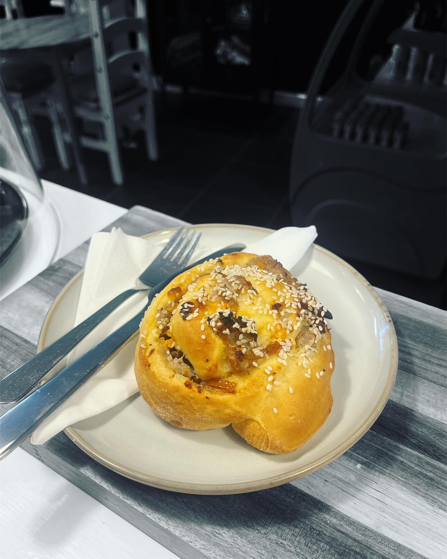 BREAKFAST BUNS ARE BACK! Soft enriched dough rolled with black pepper sausage, garlic, sticky red onion chutney, salty bacon and sharp red lester cheese, coated in sesame seeds. Toasted to order of course. They smell incredible 🤤