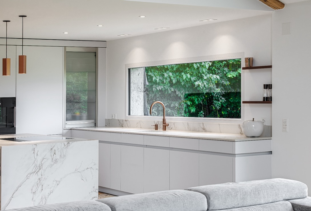 Cuisine minimaliste et élégance maximale
Cette réalisation respire la pureté et la lumière. Les lignes épurées, les tons clairs, et cette immense ouverture sur la nature créent un espace aussi fonctionnel que chaleureux.
Le choix du Dekton de chez @cosentino_swiss pour le plan de travail et l’îlot central n’est pas un hasard. Voici 3 bonnes raisons d’opter pour ce matériau :
Ultra résistant : rayures, chaleur, UV… il ne craint rien, idéal pour une cuisine du quotidien.
Entretien facile : une surface non poreuse, hygiénique et simple à nettoyer.
Esthétique contemporaine : son aspect marbré apporte luxe et sobriété à l’espace.
Un projet qui allie design, durabilité et performance.
Cuisine @ispagencements
Pictures @jorgenndobleene