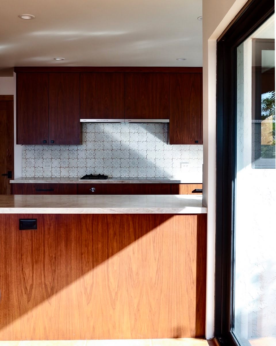 Here's a modern take with walnut and a beautiful peninsula bar, taking in the light from the patio doors.
Feeling inspired to make your kitchen warm, rich and modern?