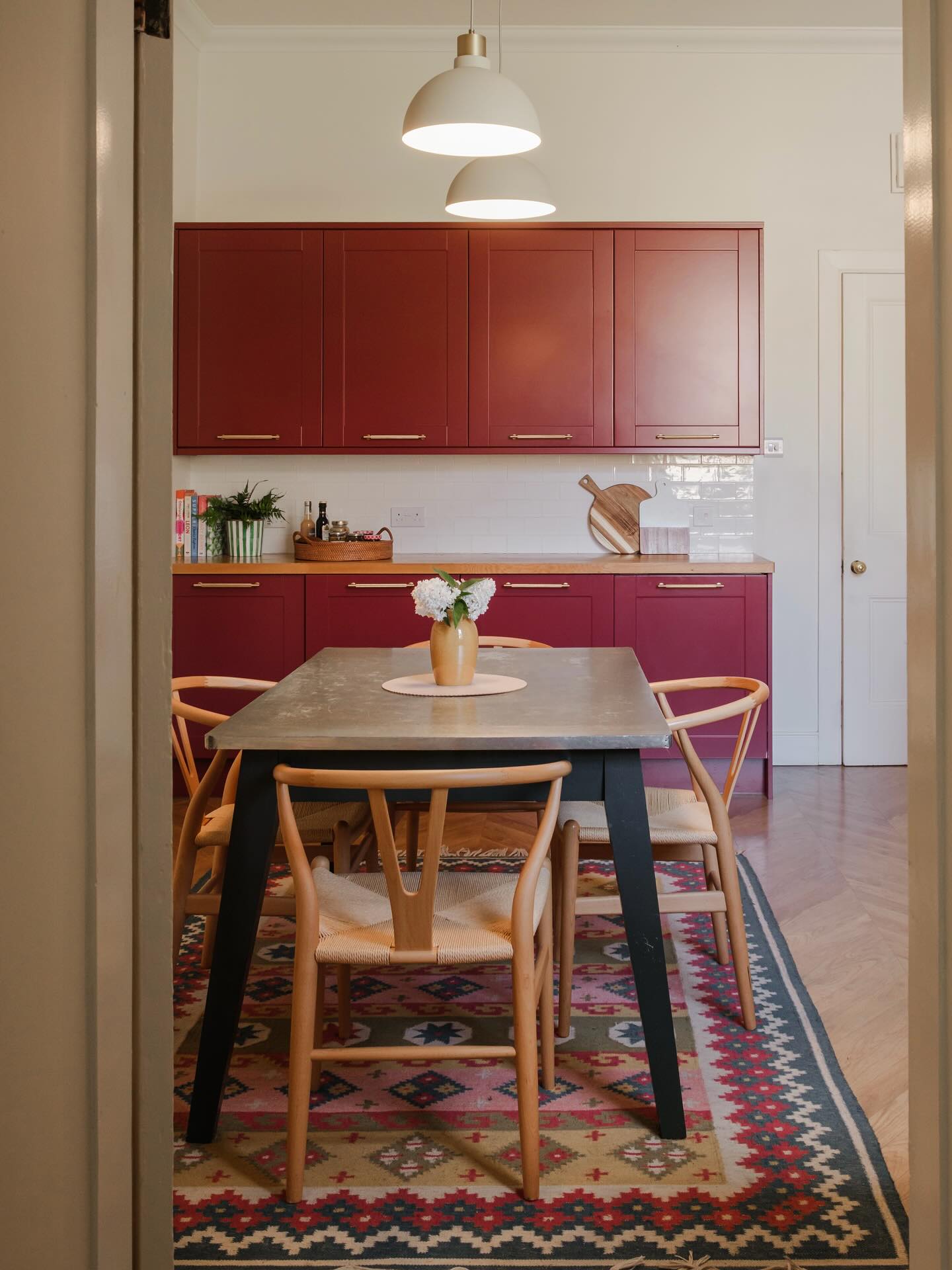 Our north facing kitchen has been through some changes since we moved into our house 10 years ago. We originally chose white cabinets from @howdensjoinery which I thought would bring some much needed light into the space. However, the room felt cold and lacking in personality.
A couple of years ago we took the plunge and asked @thesprayfactoryltd to spray the cabinets in Picture Gallery Red from @farrowandball and it has completely transformed the feel of the room. We paired the cabinet colour with a colour called Pointing for the walls, a creamy white with lots of warmth.
The beautiful rug from @weaver.green brings a big dose of personality into the room, and softens the acoustics. A huge bonus that it’s washable too.
Most of us instinctively choose light colours for darker spaces but in fact, warm, rich colours are often what’s needed to bring a north facing room to life.
📸 @katie_pryde_photography
