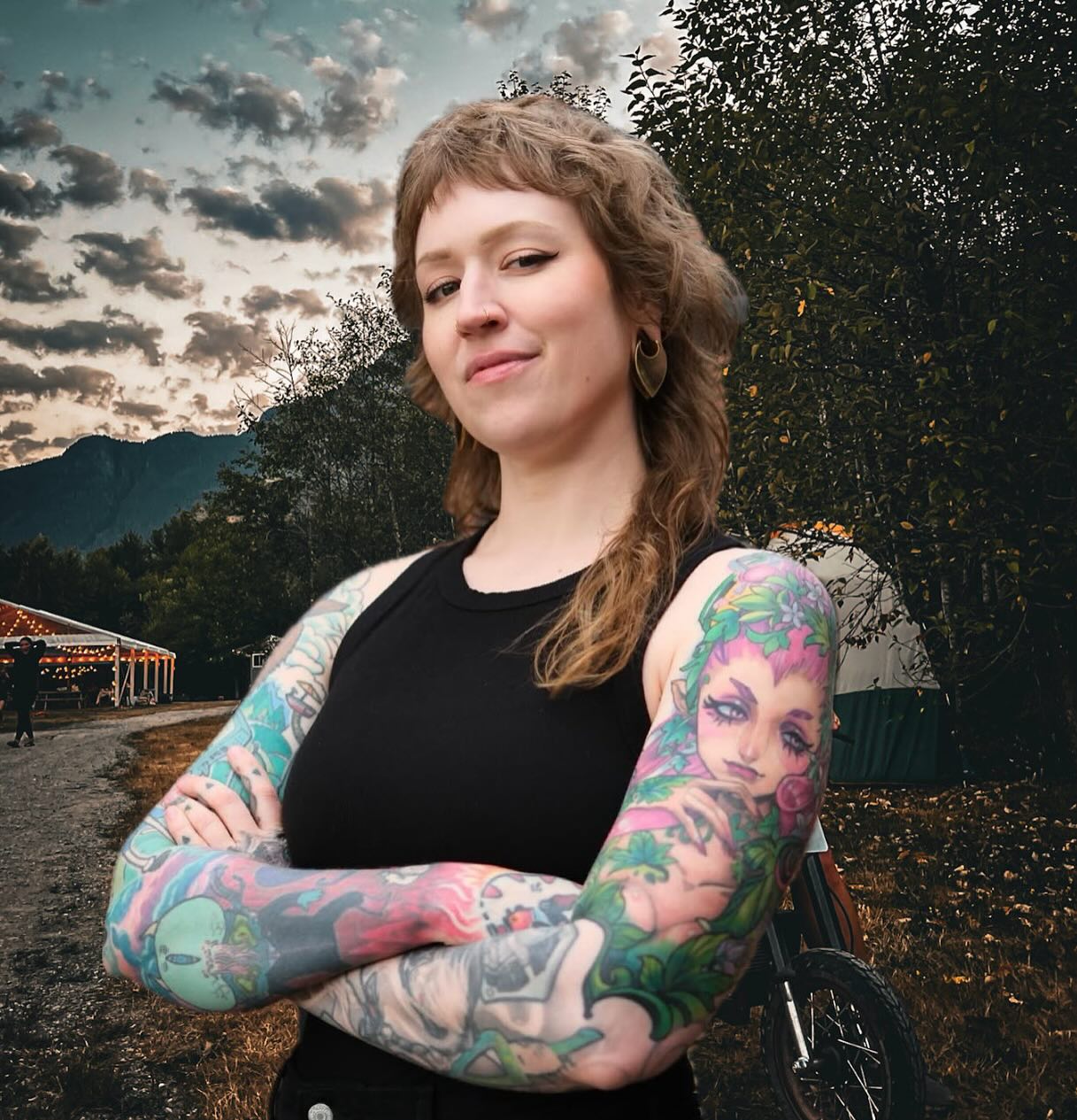 Sam Burke is a Vancouver-based tattoo artist working out of Orchid Oddities Tattoo. With a foundation in traditional tattooing, Sam’s work stretches from bold lines and rich colour palettes to fine lines and stipple shading. She loves tattooing video games, anime and all things nerdy, but also is obsessed with script and florals. While colour is her specialty, Sam is open to all styles and loves collaborating with clients to bring their unique ideas to life!
Before tattooing, Sam worked for over a decade in the film industry as a Special FX Makeup Artist, a background that sharpened her eye for detail, creativity under pressure, colour theory, and a deep understanding of many skin tones and types. She has always been an artist, drawing and painting since she could hold a pencil, spending her teens and twenties as a professional artist through many industries.
With every tattoo, Sam focuses on design flow, thoughtful placement, and client education in an inclusive and comfortable environment. She always says, “There are no stupid questions, we can’t know until we know!” and is available through the tattoo and healing process to help ease any nerves you might have!
Sam is so excited to be working beside Lacey for this year’s Moto summit and can’t wait to meet you all! These two women have worked alongside each other for multiple tattoo conventions and guest spots, share their love of farm life and solid, long-lasting tattoos. They bring completely different career experiences to the table, which makes their dynamic fun, supportive and creative as hell!