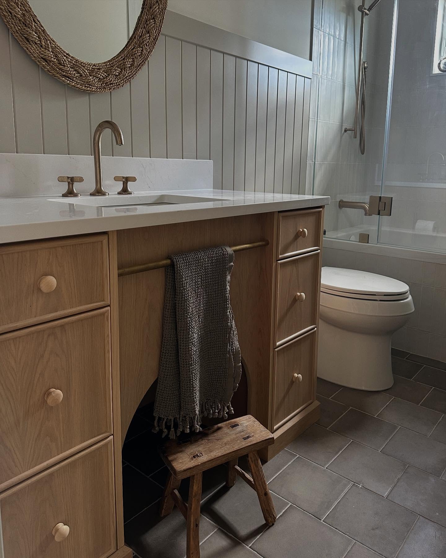 This bathroom vanity was designed with pure intention. We used the void space under the sink in a not-so-typical yet very functional way. We hollowed out a space under a millwork arch to tuck a stool in. This keeps it out of the way for those who don’t need it, and also allows the door to the bathroom to swing open and closed easily without having to slide the stool out of the way (learned this one from experience!) We also integrated a brass towel bar for added function and design detail. We love finding ways to marry form and function!