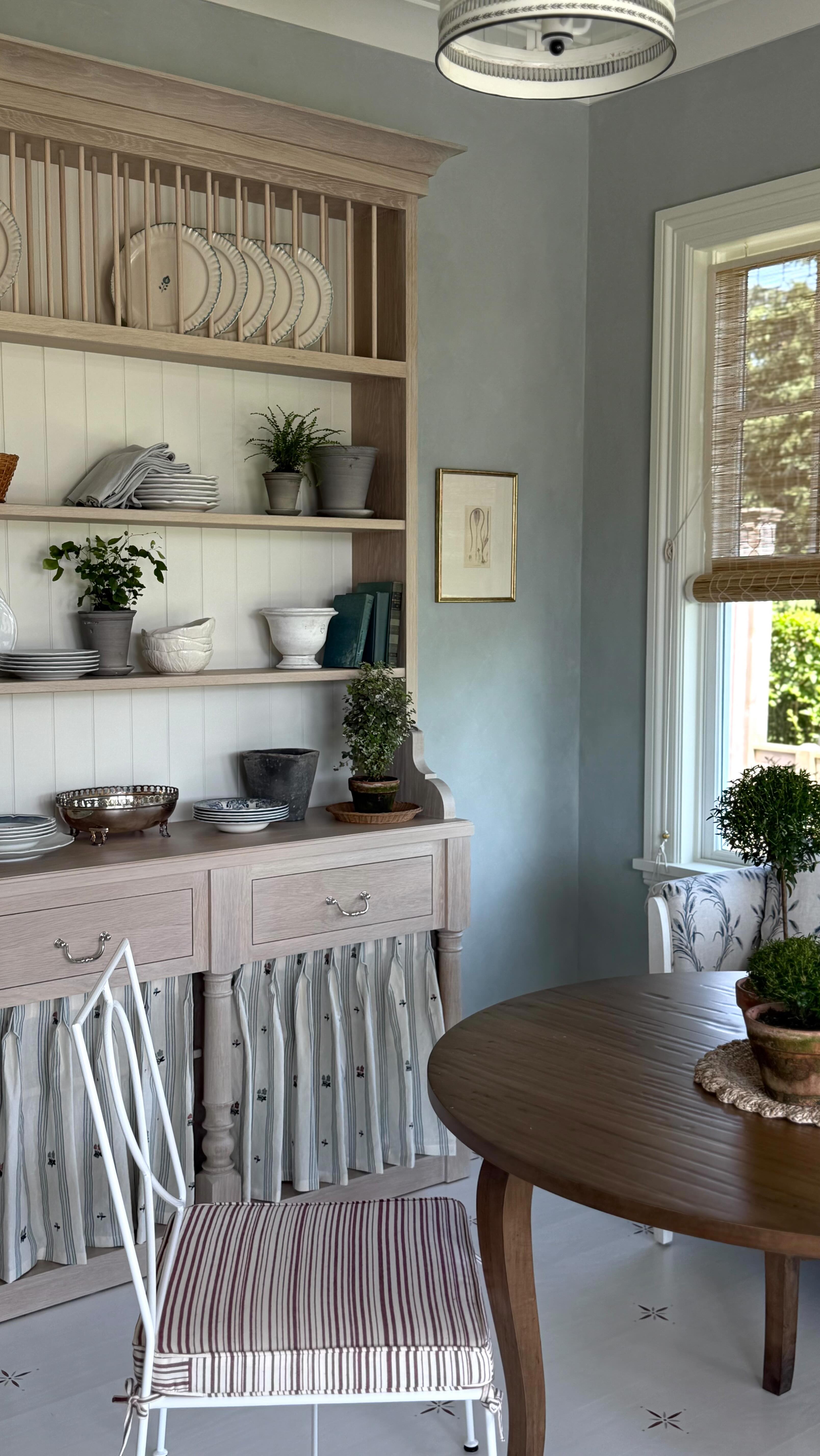 Warm breeze, a cup of coffee, and this cozy breakfast nook is all I need for summer 🌿A front runner for my favorite room at our Hamptons Garden project with lime washed walls, painted floors, and our new customizable hutch from @uniquekitchensandbaths. #hamptons #interiordesign #eastcoastal