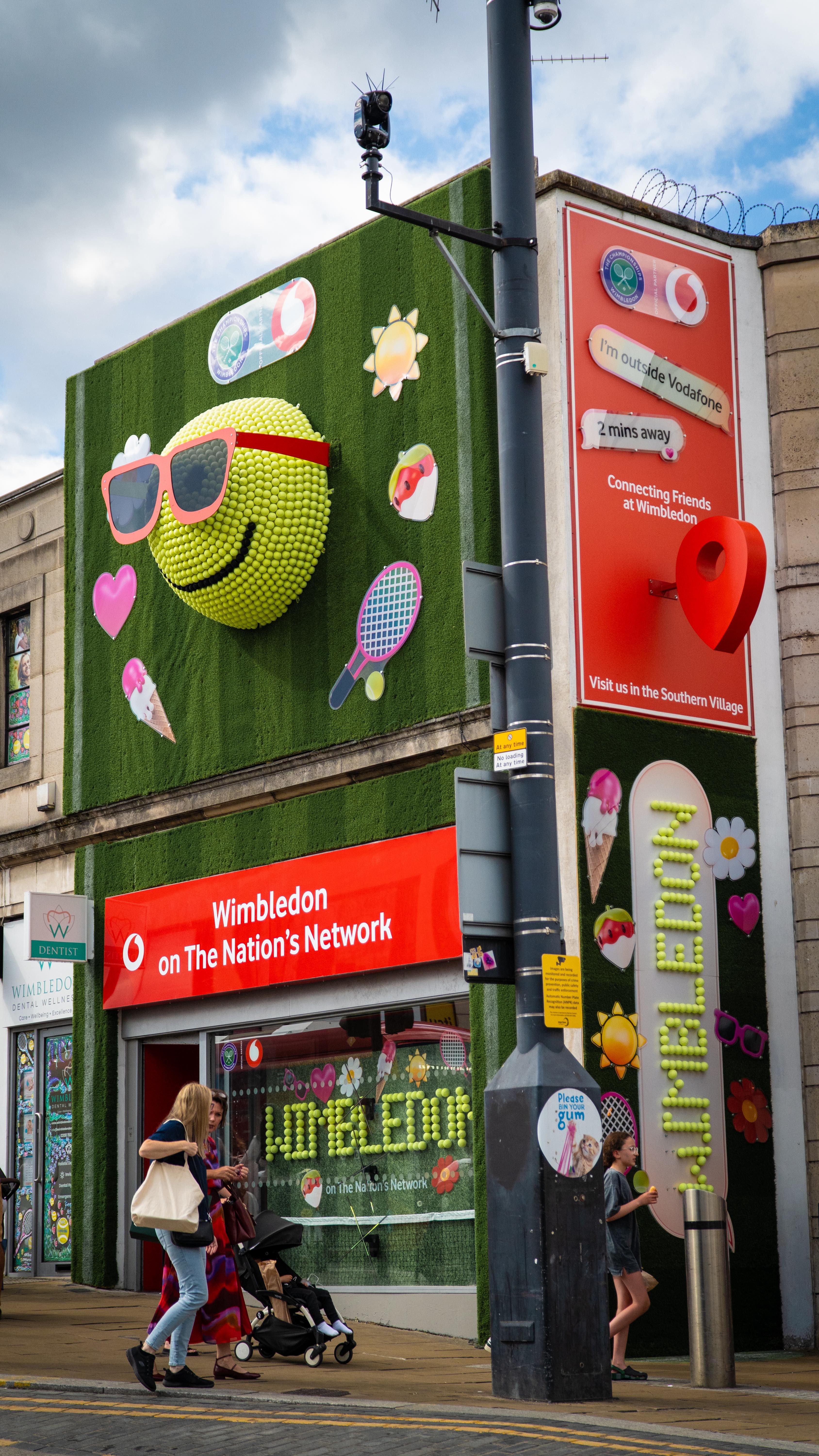 Stylo served up a bold Wimbledon centrepiece: a custom 1800mm spun aluminium half-dome, flocked in ‘tennis ball green’ and decked out with 1,250 real tennis balls forming a smiling emoji—complete with Vodafone Red dibond sunnies.
The store’s exterior got the full Wimbledon makeover too, covered entirely in real astro turf. We spelled out “Wimbledon” in tennis balls inside and out—because why not go all in?
To finish, we added gloss acrylic summer emojis and a giant Vodafone-red location pin to get people snapping, tagging, and sharing the love. 🎾📍
#Wimbledon #Vodafone #RetailDesign #StoreTakeover