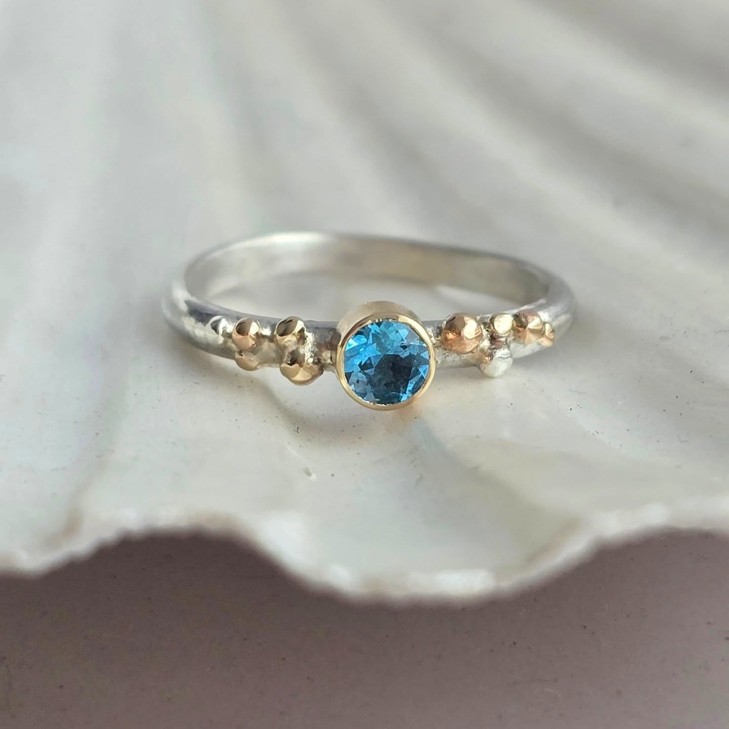 ✨ Sea Spray at Golden Hour ✨
There’s something truly magical about that golden moment before sunset — when the light hits the sea just right, and the waves sparkle with hints of gold and blue.
This new edition of Sea Spray Ring captures that feeling perfectly 🌊☀️
A Blue Topaz sits in a 9ct gold setting, accented with delicate gold granulation.
Each ring is one of a kind and inspired by those magical sunsets by the sea.
#SeaSpray #BlueTopazRing #GoldenHourVibes #HandmadeJewellery #JerseyArtist #GoldAndSilver #NatureInspiredJewellery #jerseyci #oceanring