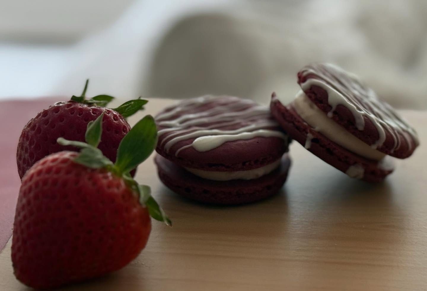 Strawberry cheesecake macarons drizzled with white chocolate