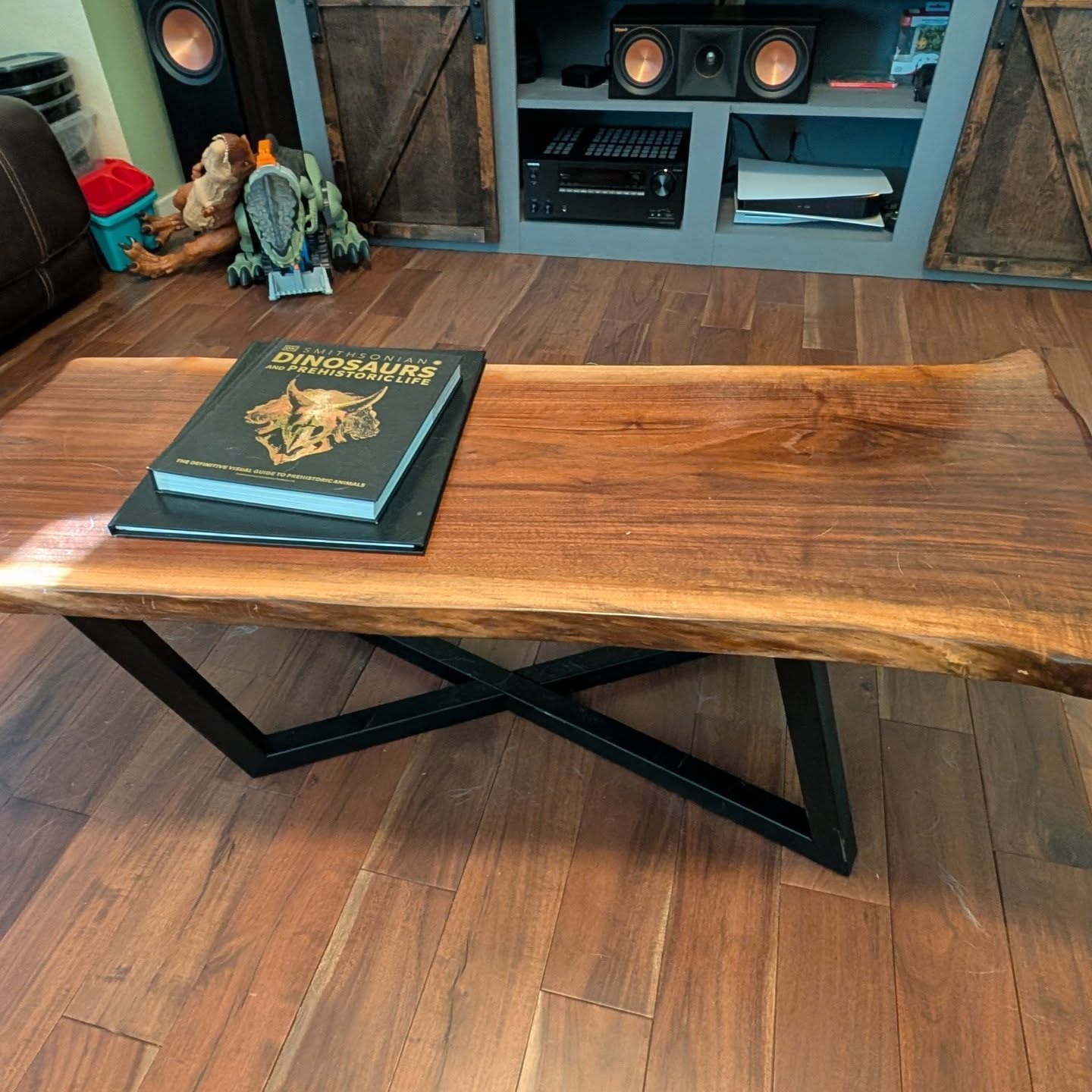 A custom coffee table with a beautiful piece of walnut live edge and some funky, black metal legs. Instead of the normal straight cuts on the end, we spent a lot of time jig sawing and sanding to create natural curves to give the live edge feel all the way around the tabletop.