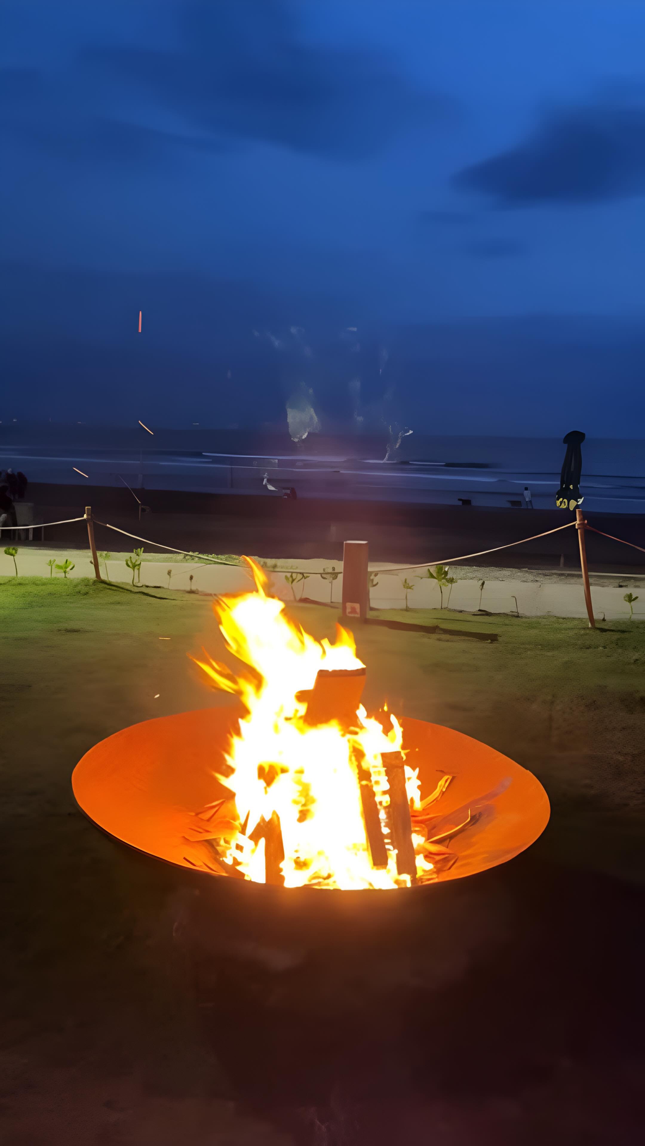 Flames, salt air, and the night warming up behind you.