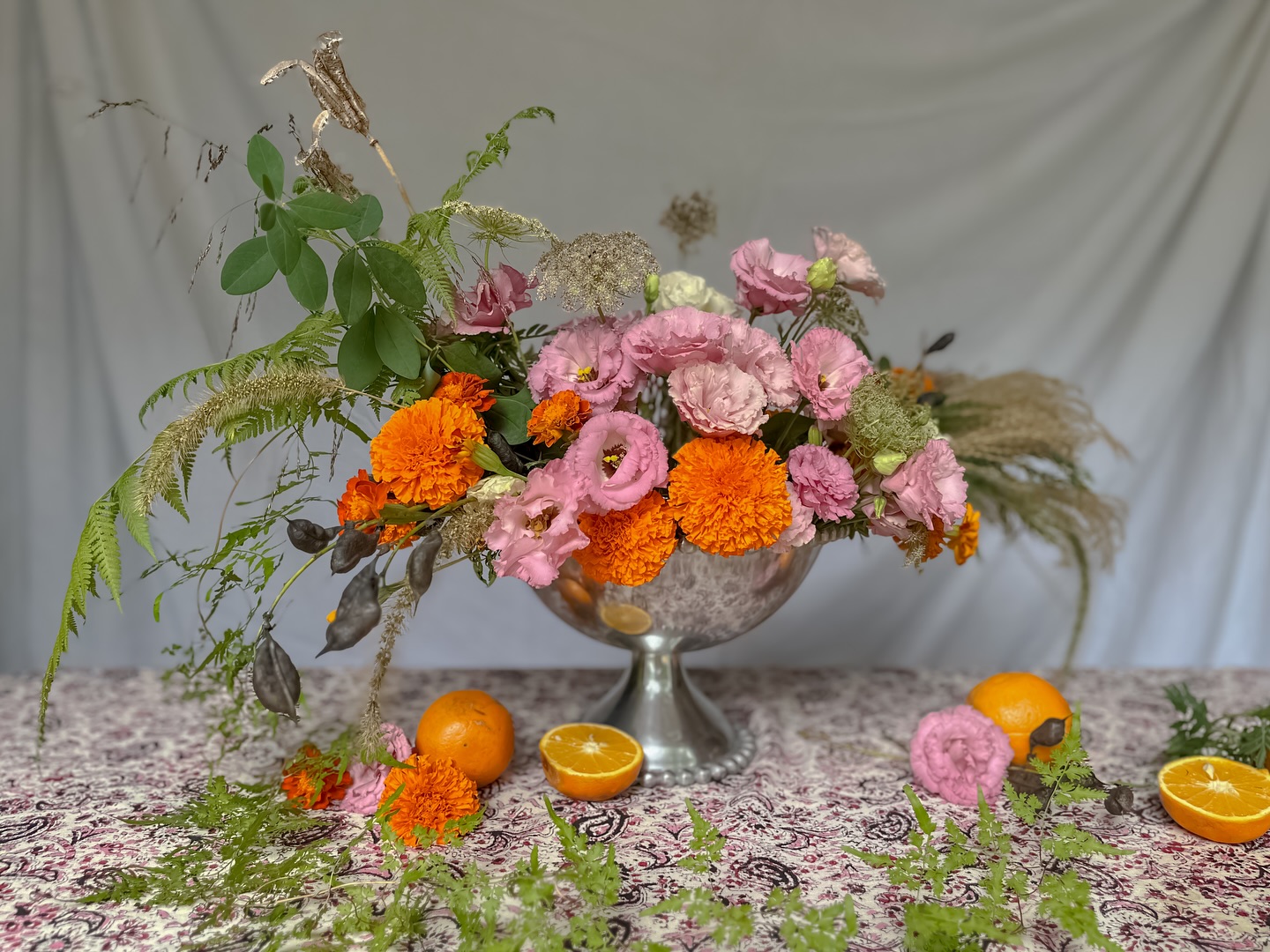 Cabaret party arrangement. While I could’ve gone with an obvious red, soft pinks and oranges weren’t lost amongst the moody vibes of the Kit Kat Klub Lexi created for an evening at @landfamilyhome. The ruffled pink lisianthus reminded me of fluffy skirts and the grasses and ferns I plucked from the side of the road are reminiscent of feathers.