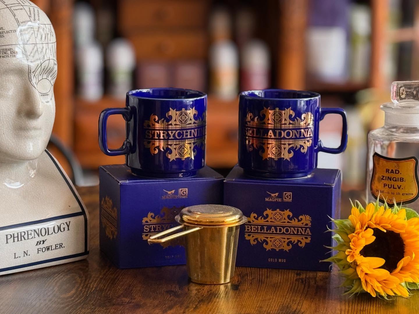 What’s your poison? ☠️
We might be just a tad obsessed with our brand-new apothecary mugs, and honestly, who could blame us? 😍
Inspired by the iconic 1975 Poison mug series designed by the talented John Clappison of Hornsea Pottery, this magical collaboration with Magpie has brewed up something special old apothecary styles. Here’s the scoop:
✨ Cobalt blue glazed stoneware that’s as stunning as it is sturdy.
✨ Real gold (yes, you read that right!) plated ‘poison’ design that adds a touch of luxe.
✨ Comes in a fabulous gold-foiled and cobalt printed gift box—perfect for gifting or treating yourself!
✨ Capacity: 330ml.
✨ Dimensions: 8.5cm (diameter) x 8.5cm (height).
Now, a quick note—these beauties aren’t microwave or dishwasher safe. But honestly, who microwaves tea anyway? And frankly, who cares just look at them! 😍
The cherry on top? You can snag one from our apothecary—choose between the enchanting Belladonna, aka Deadly Nightshade still used by herbalists today (hands off though it’s a schedule 20 herb) or the striking Strychnine versions.
Feeling thirsty? We got you. Swing by for a brew and sip on our hand-blended herbal teas or adaptogenic coffees, all served in your very own poison mug! ☕💚
