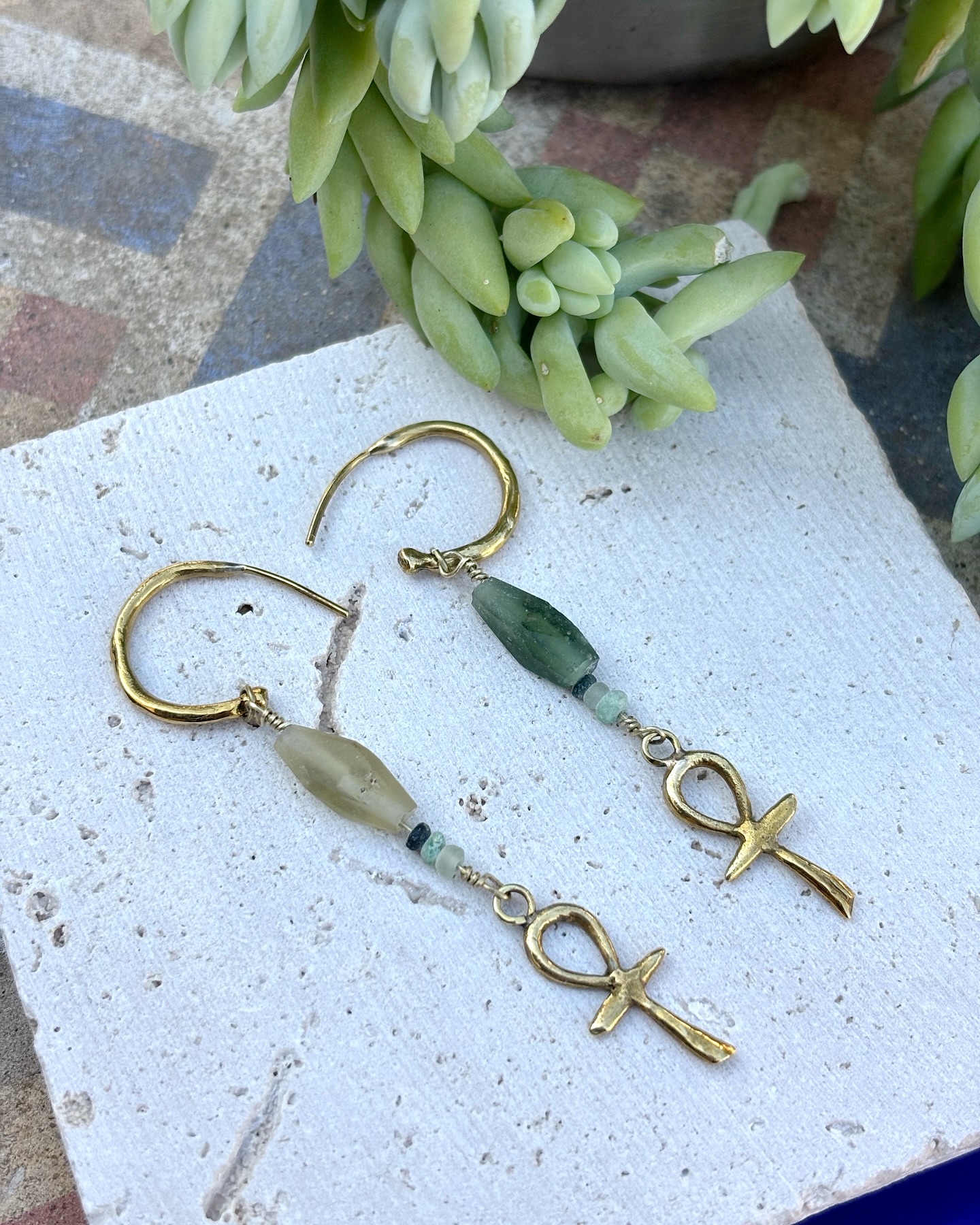 ANKH earrings 𓋹 Playing with our new ancient roman glass ✨ In Istanbul, I bought an old Afghan jade bracelet for myself. I was like a child, very happy with it ❤️ I lost it that same day. It affected me so much that, like a crazy, I started looking for similar materials. Without any luck, but I found some ancient Roman glass, found during excavations in Afghanistan, which Afghan artisans had worked to create jewelry. And I thought, how good that I lost it because I found another treasure! In the end, I returned to the store where I had found that jade bracelet and found a few more after searching and searching 🤗🍀 🧿So, the story has a happy ending! To learn more about these ancient crystals, you can see my stories where I show you the new material that will slowly be transformed into jewelry. 💍
#ancestraljeweley #handcraftedwithsoul #ancientroman #ancientromanglass #ancient #consciousfashion #slowmadejewelry #ancientwisdom #ancientjewelry #joyeriatradicional #traditionaljewelry #joyeriaconalma #souljewelry #consciousjewelry #ethicalbrand #slowjewelry #middleeastern #middleeasternfashion #middleeast#middleeastjewelry #ankh #ankhjewelry #egyptianjewelry #ancientegypt #ancientegyptian
