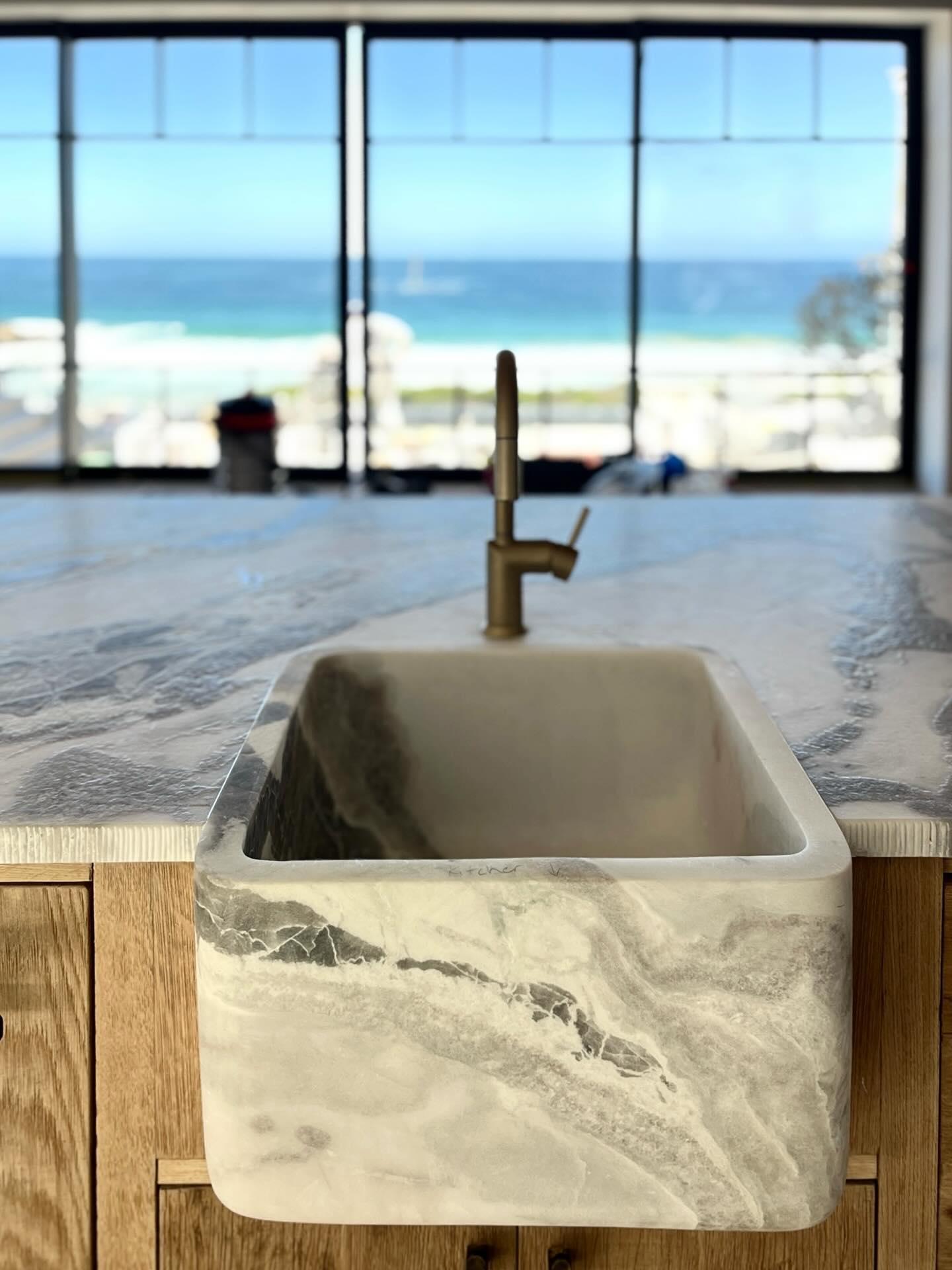 SCULPTED BY NATURE, REFINED BY DESIGN
This Calacatta Oyster masterpiece flows seamlessly from kitchen countertop to basin — all carved from solid Namibian marble. With soft blues, sea greens, greys, and crisp whites, it echoes the colours of the ocean just beyond the windows. A bold, natural centrepiece in a home by the sea.
#CalacattaOyster #NamibianStone #SolidMarbleSink #CoastalLuxury #NaturalStone #StoneArtistry #KitchenDesign #OceanViewHome #MarbleMasterpiece #TimelessElegance