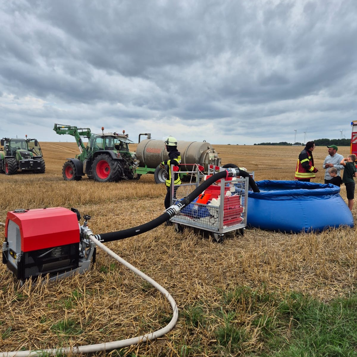 Landwirtschaft trifft Feuerwehr – Gemeinsam gegen Feldbrände
Pilotprojekt für bessere Zusammenarbeit in Titz erfolgreich gestartet
Feldbrände stellen in den Sommermonaten eine besondere Herausforderung dar. Vor allem die gezielte Einbindung von Landwirten und ihren Gerätschaften kann die Arbeit der Feuerwehr entscheidend unterstützen. Beispiele sind das schnelle Anlegen von Wundbrandstreifen in Beständen oder der Wassertransport mit landwirtschaftlichen Fahrzeugen wie Güllefässern.
Um die Zusammenarbeit künftig noch effektiver zu gestalten, trafen sich jetzt auf Einladung der Feuerwehr Titz Feuerwehreinheiten und Landwirte aus der Kommune zu einem Erfahrungsaustausch. Initiator und Wehrleiter Stefan Giesen hatte dafür ein vielseitiges Infoprogramm auf dem Acker vorbereitet- darunter
Pump and Roll-Löschmaßnahmen bei Feldbrand, das Anlegen einer Riegelstellung durch die Feuerwehr sowie der Aufbau von Wasserübergabepunkten direkt auf dem Feld aus dem Güllefass.
Mehr Infos dazu folgen