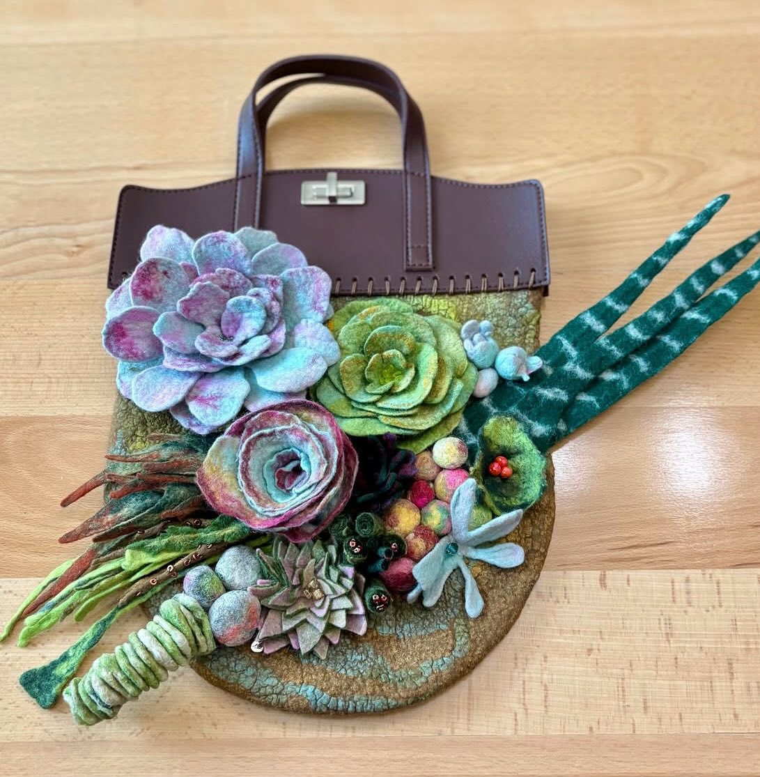 Amazing work by NEFG member Memory Bradley. “Who says you can’t take your garden with you?” is her description of this handmade wool purse with a wool garden attached. @memorybradleyart