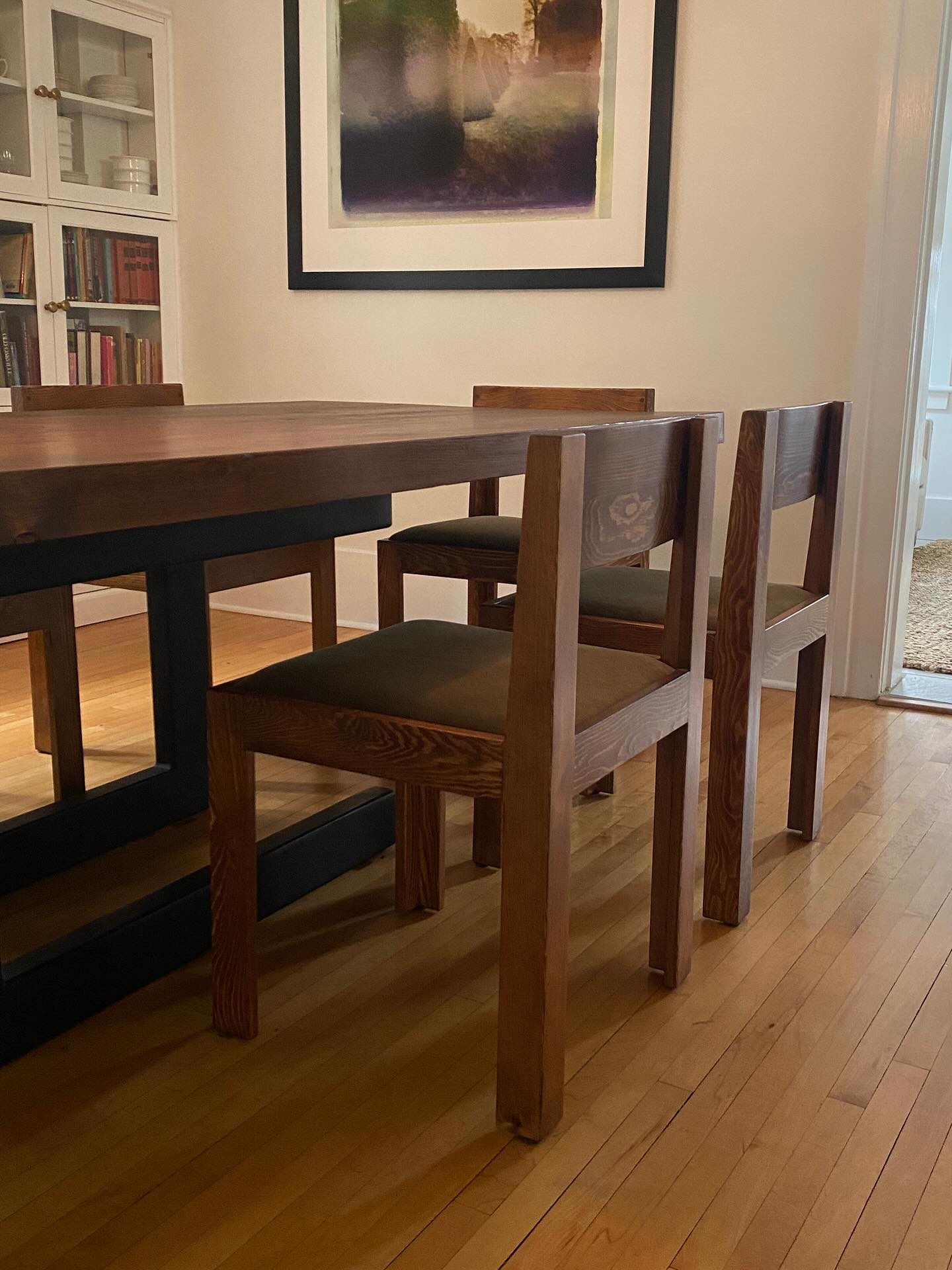 I built this table for a wonderful family about 12 years ago. In fact, it’s in the first photo I shared on this page. The 3” thick wood slabs came from an old hockey rink that was torn down in their hometown Caronport, SK. They asked that I refinish the rustic table and design 8 chairs to go with it. We collaborated on the design. They knew the exact style and upholstery they wanted. The chairs are made from Douglas Fir just like the table and feature through mortise and tenon joints as well as a curved backrest that is rabbited and doweled into the frame. I used the same stain and finish to bridge the 12 year gap and to ensure they last a few dozen more years.
