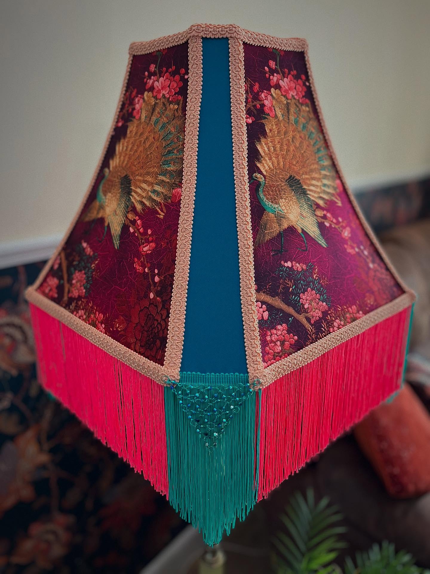.
Name: Mei (Meaning - Gorgeous/Plum)
Colour: Turquoise/Fuchsia/Peach/Peacock
Lamp Frame: Cut Corner Square Bell 20”
Lamp Style: Table/Standard Lamp
Category: Vintage Glamour
£349.99
Go to www.ritzyroguelampshades.co.uk
