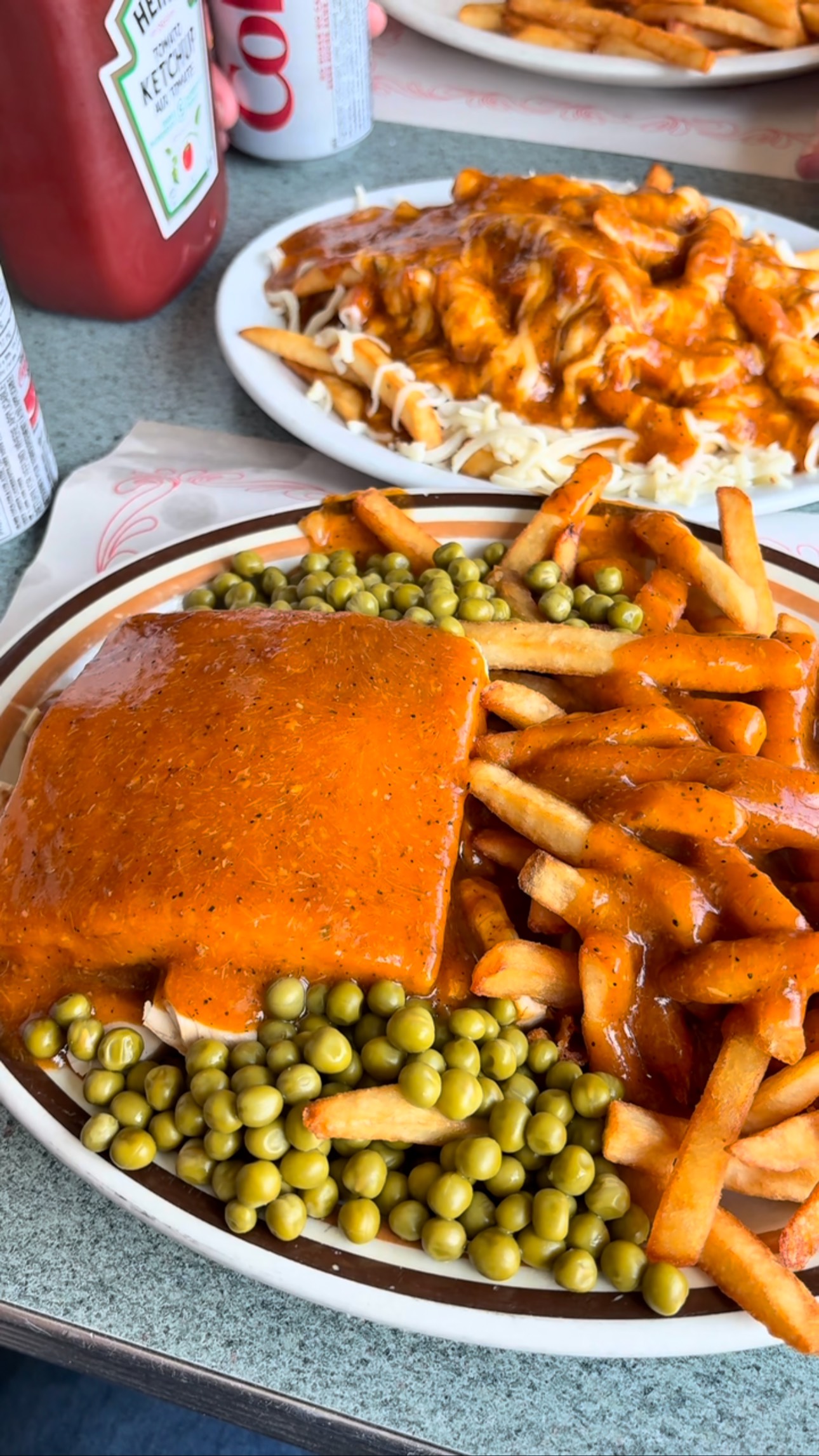 National Sandwich Month: Day 19 takes us to Louis Pizzeria in Cornwall for a Canadian classic: the Hot Chicken Sandwich.
It includes tender chicken inside soft bread, smothered in a rich gravy and fries on the side. This diner staple is especially beloved in Québec and Eastern Canada, where it’s known simply as “Hot Chicken”.
It’s my last sandwich here in Cornwall before I head home and today I’ve got company: Felix, along with his grandpa (If you know, you know, I may have been in his office a few times 🤣)