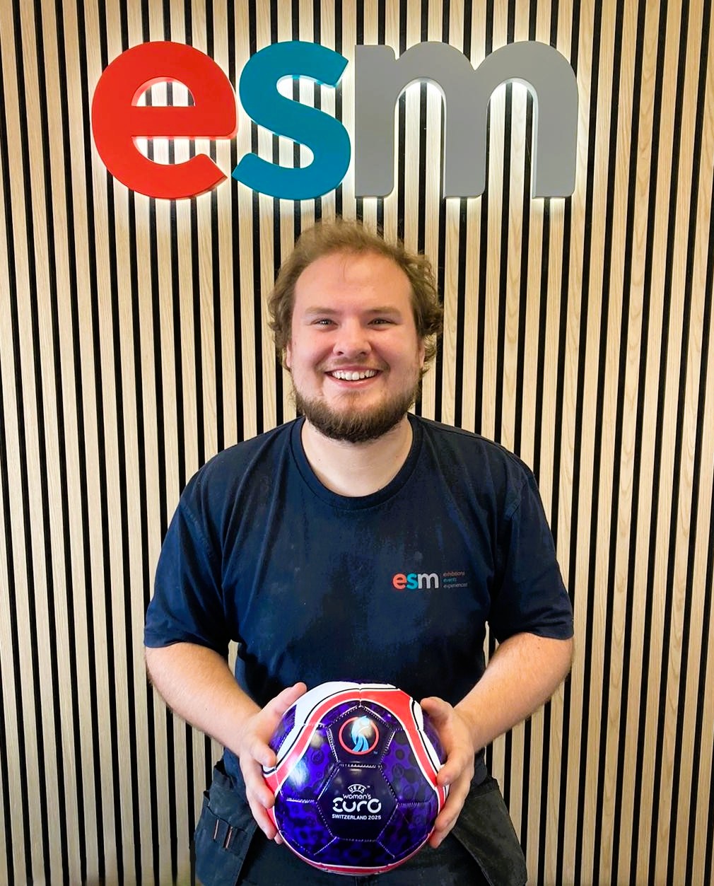 We're a bit late to the party, but we've just been too busy celebrating football coming home! 🏆
This year we ran a 'just for fun' sweepstake revolving around the UEFA Women's EURO 2025; colleagues from projects, production and the workshop all drew a nation at random and were encouraged to follow their team through the tournament.
Our carpenter Sam Fairs was lucky enough to draw the winners (England!), so here he is with his prize (a women's euro football) in front of the lovely Acupanel® logo feature wall in our main office (Yes, we do office fit outs 👀).
It was a great way to get people engaged with women's sport (something we're all quite passionate about in the office) whilst raising awareness of the inspirational stories behind the lesser known teams' and players' struggles for recognition and funding.
The sport has grown so much in the last few decades, and we hope to see it continue to break into the mainstream and reach parity with the men's game. It definitely inspired some of us to get involved!
Well done Sam, and well done to the Lionesses on retaining their title - but this time we're all winners really. Here's to the hat-trick next time! ⚽
@_samfairs_ @uefa @weuro2025 @lionesses
#womenseuro #lionesses #england #football #winners #euro2025 #womenseuro2025 #itscominghome #sweepstake #culture #switzerland #womeninsport #equality #equalityinsport #inspirational