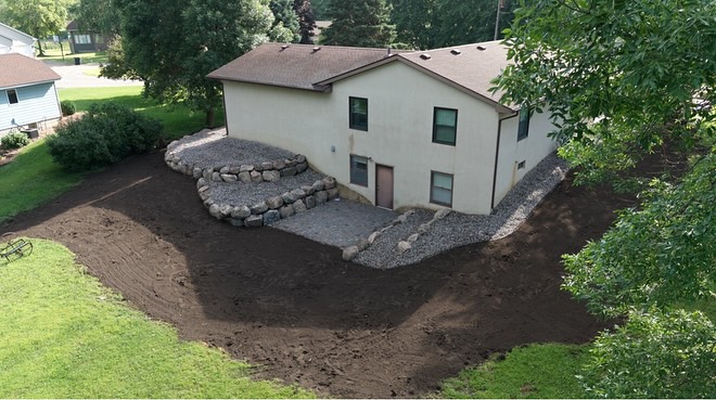 Walls that fall get replaced with walls that last. This yard got a full upgrade — boulders stacked right and a paver patio built to handle Minnesota weather. 🌿🪨