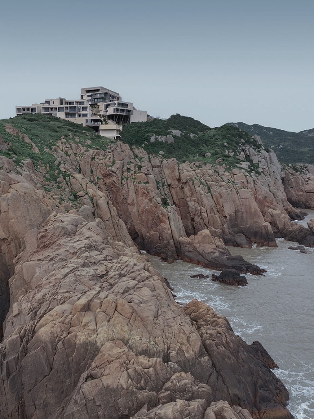 Lost Villa · Huanglong Island Lighthouse Hotel — un projet où l’architecture devient un passeur entre le temps et la nature.
Sur l’île de Huanglong, dans l’archipel de Zhoushan, les bâtiments reprennent l’échelle des anciennes maisons de pêcheurs et descendent en cascade le long du relief. Au lieu de fondations massives, ce sont des structures suspendues qui permettent aux volumes de « flotter » au-dessus des récifs, préservant le paysage intact et créant un espace intermédiaire entre le naturel et le construit.
Le chemin vers l’hôtel devient un scénario architectural minutieusement pensé : depuis le port, la route guide le regard pas à pas à travers des séquences de vues et de pauses, jusqu’à ce qu’il se fixe finalement sur le phare. Ici, l’architecture agit comme une mise en scène — elle rythme le mouvement, place des accents et plonge le visiteur dans une expérience lente, presque cinématographique.
Même à l’intérieur, l’échelle humaine reste essentielle : les fenêtres cadrent la mer, la lumière et le vent, transformant chaque instant en suspension du temps. En conservant les formations rocheuses et en utilisant la brique jaune locale, les architectes ont tissé l’hôtel contemporain dans l’histoire et la géographie de l’île. Quand les rayons du soleil traversent les ouvertures et tombent sur les récifs, nature et architecture respirent à l’unisson.
✦ Le projet est signé par WJ STUDIO, reconnu pour sa capacité à réinterpréter le contexte local en intégrant l’histoire, la culture et le rythme naturel dans un design contemporain. Leur architecture n’est pas un objet figé, mais une expérience vivante, capable de raviver le temps et la mémoire.
#architecture #designcontemporain #wjstudio #lostvilla #archipelZhoushan #hoteldeluxe #architectureetchitecture #architectureetchronos #hoteldesign #architecturedurable #architectureetnature #spatialexperience #minimalisme #hôteldexception #worldarchitecturefestival
Image : www.wjstudio.cn @wjstudio.cn