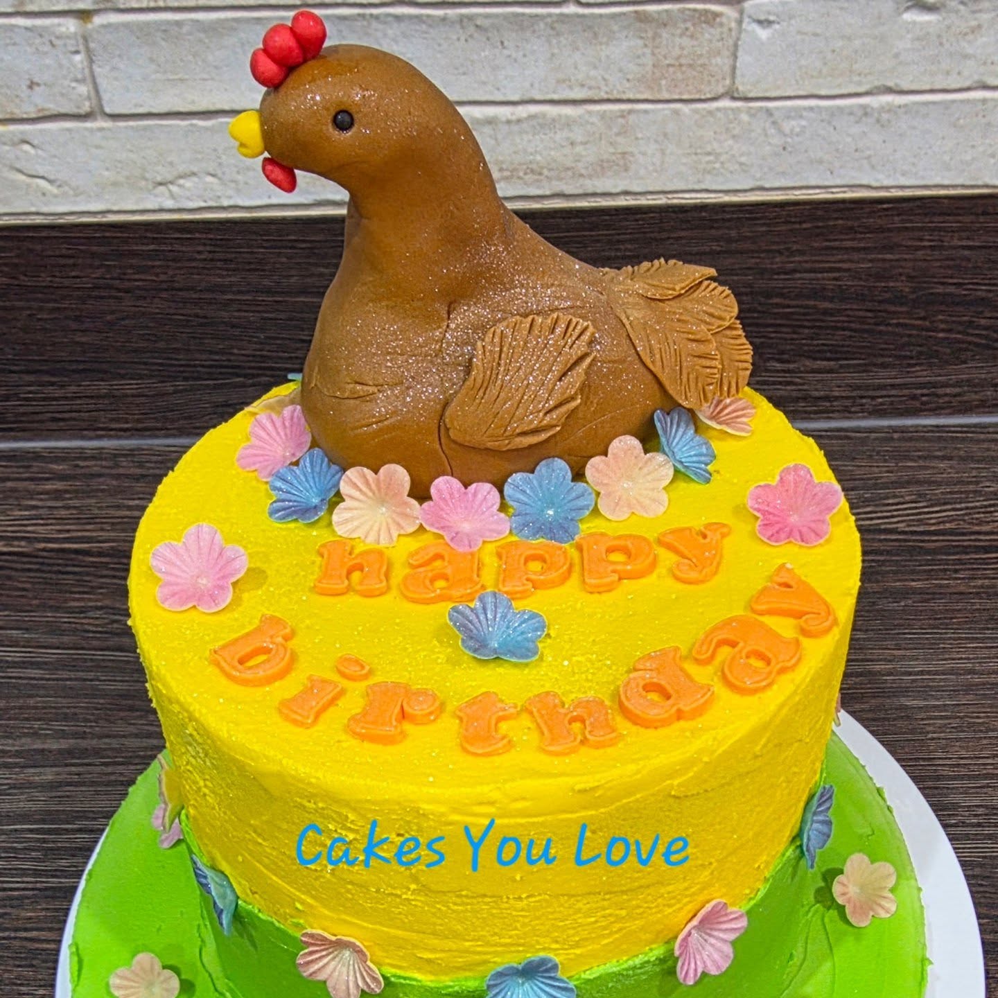 A vanilla sponge filled and decorated with vanilla buttercream. Handmade chicken with added wafer flowers for colour