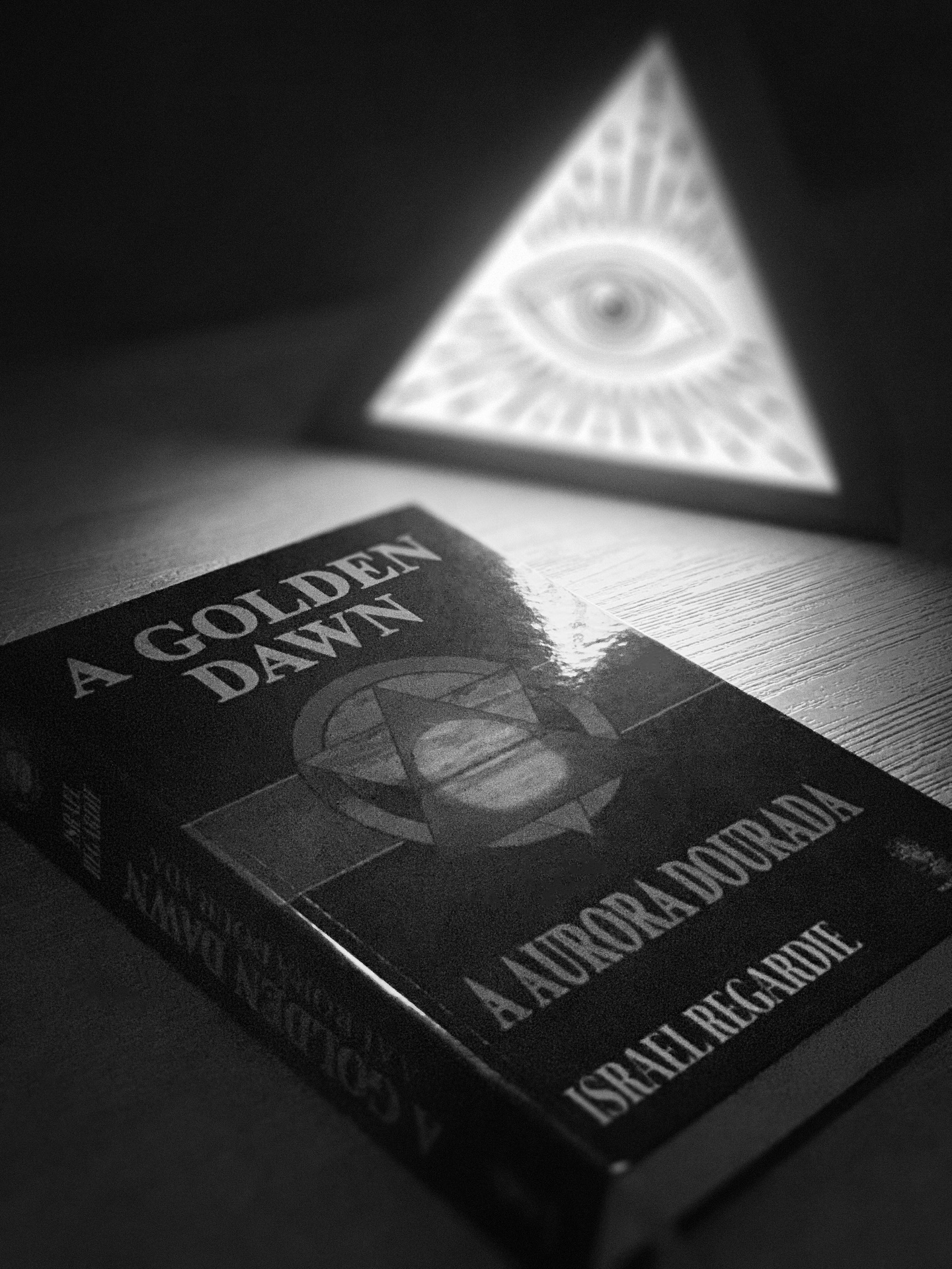 “A Golden Dawn: A Aurora Dourada”, de Israel Regardie (Ed. Madras, 2023), não é apenas uma obra literária; é a chave que abriu as portas de um dos mais influentes e enigmáticos sistemas de magia do Ocidente. No final do século XIX, a Ordem Hermética da Aurora Dourada surgiu em Londres como uma grande síntese de tradições esotéricas. Fundindo a Cabala, a astrologia, a alquimia e o tarô, ela se tornou um farol para aqueles que buscavam a iluminação e o domínio das artes mágicas. No entanto, com a fragmentação da Ordem, seus ensinamentos corriam o risco de desaparecer.
Israel Regardie foi um dos últimos iniciados da Golden Dawn. Antes, fora secretário e protegido de Aleister Crowley. Regardie presenciou a decadência de uma tradição que considerava um tesouro para a humanidade e temeu que seu legado fosse consumido pelo esquecimento e pelas disputas internas. Então, ignorando os juramentos sagrados de sigilo, ele compilou e publicou os rituais, as aulas e a filosofia da Ordem em um único volume monumental. Para muitos tradicionalistas, foi um ato de traição, um sacrilégio que expôs o sagrado ao olhar profano do público. Para Regardie, porém, era um ato de amor e de resgate, uma forma de salvar a magia para que ela pudesse viver e florescer.
A publicação causou um escândalo, mas seu impacto foi revolucionário. Deixou de ser um conhecimento restrito a uma elite e se tornou o alicerce para uma nova era de espiritualidade. Se tornou uma “bíblia” para a magia cerimonial moderna, influenciando a formação de novas tradições e ordens. A Wicca, por exemplo, embora com raízes próprias, absorveu e adaptou elementos dos rituais e da estrutura mágica ali apresentados. O mesmo se aplica a outras ordens thelêmicas e herméticas que, hoje, utilizam a base da Golden Dawn para suas próprias práticas. O livro é, portanto, mais do que um guia. É o legado de uma tradição secular que ainda florescesse em novos e vibrantes jardins do ocultismo.
#goldendawn #auroradourada #magia #hermetismo #ocultismo #esoterismo #magick #magic #encruzilhada #encruza