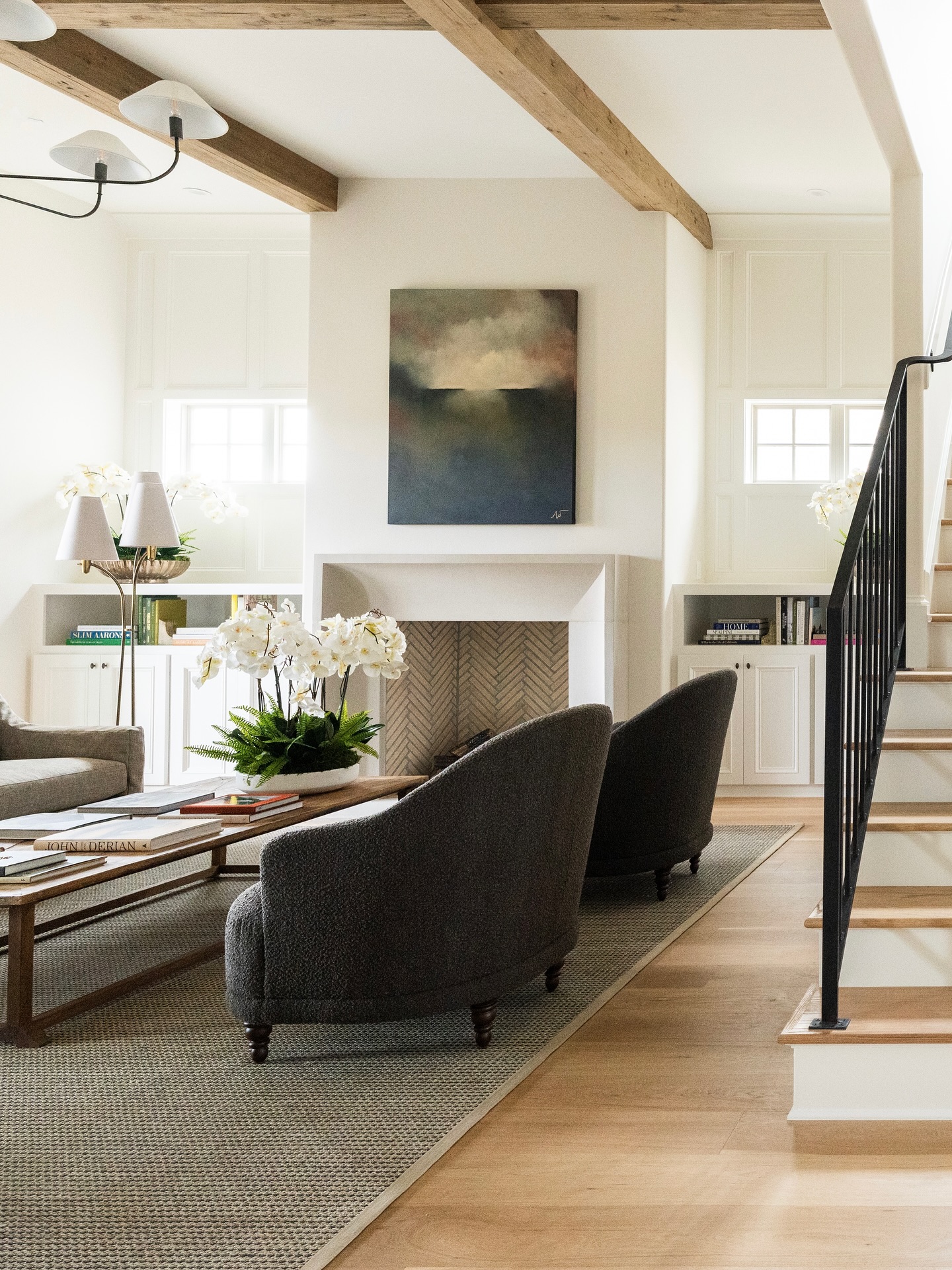 The family room, reimagined for fall 🍂
This space is layered with warmth—natural wood beams, textural upholstery, and a moody piece of art grounding the fireplace. The palette feels crisp yet comforting, a perfect backdrop for gathering as the days grow shorter. Would you spend your autumn evenings here?
Builder: @dickensbuilt
Photography: @jennifer.saltsman.photography
Artist: @wellonart
#interiordesign #customhomedesign #interiors #art