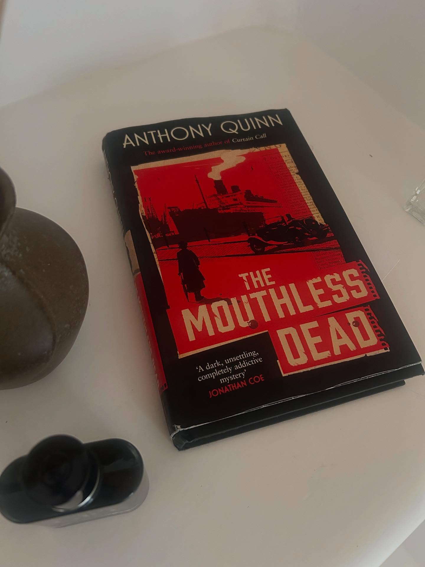 We kick off the Den’s month of killer reads with our Book of the Moment, ‘The Mouthless Dead’, by one of The Reading Den’s much loved fiction writers, Anthony Quinn. This intriguing, imaginative and gripping novel is the story of a real unsolved murder crime with a new narrative and a resolution as to what has been described as ‘the perfect murder’. This story is worth hearing out so read on… The reader is firstly presented with the historical facts of the case: One night in 1931 William Wallace is handed a message at his chess club from a Mr Qualtrough, asking him to meet at an address, 25 Menlove Gardens East, only to find it did not exist. Upon returning home two hours later, Wallace discovers his wife beaten to death in the parlour. The elaborate nature of Wallace’s alibi in which he stopped a policeman and passers by en route to Menlove Gardens pointed to him being the culprit. Wallace was subsequently arrested, tried and found guilty and sentenced to be hanged. However with the support of his employers ‘at the Pru’, Wallace’s sentence was overturned. Wallace walked free and the killer was never found. Having presented the historical facts of the case, Quinn scrolls forward some 15 years, when the murderer’s true identity continued to be rife and the retiring Inspector Key, who worked on the Wallace case, is considering it once more. It is easy to get hooked into this story, so it’s a joy to read. It is only a shame that Wallace’s wife, Julia will remain one of the ‘mouthless dead’. But perhaps through fiction her voice has been found. Still in paperback but worth tracking down as an e-book or audiobook or even in your library!
.
.
.
#themouthlessdead #anthonyquinn #bookclubofinstagram #ınstabook #unsolvedmurders #unsolvedmysteries #murdermystery #lovefiction #loveliterature