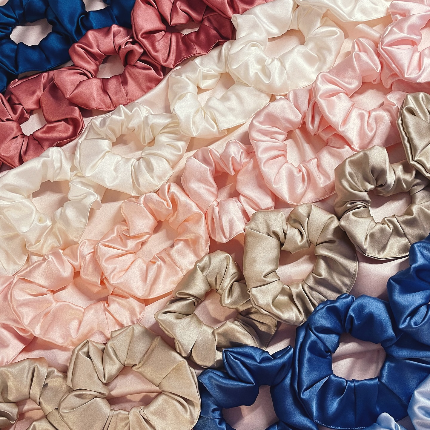 Why is it so satisfying to line scrunchies up like this? It always reminds me of the part during Be Our Guest in Beauty and the Beast when the plates dance in lines across the screen!
My silk scrunchies are a classic for a reason (Iāve been making them for nearly 10 years!) and with 28 colours and prints to choose from, you wonāt be able to stop at just one.
Image description- 1. rows of silk scrunchies arranged by colour (teal, mid pink, white, pale pink, golden beige, mid blue and finally pale blue) in diagonal rows
2. Close up of three rows of silk scrunchies in white, pale pink and golden beige