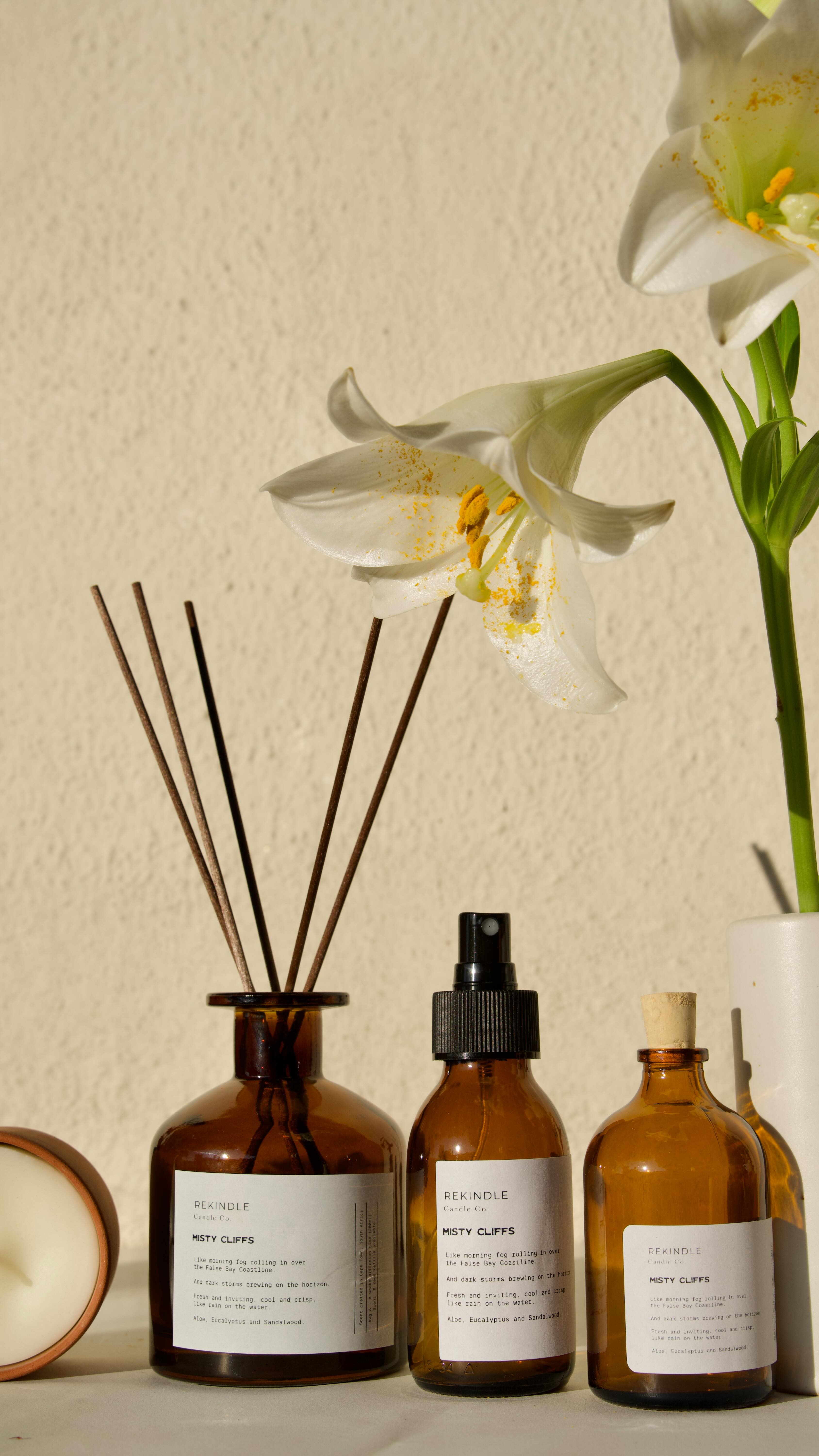 Introducing the Rekindle Home Fragrance Set.
A curation of products to keep your entire home filled with your signature scent. Perfect for gifting, or treating yourself, the box contains a Large 3-wick ceramic candle, a smaller 100g candle, a diffuser and a room spray.
The set can be ordered in any scent of your choosing, but here are some reccomendations if you’re struggling to choose.
Swartland Summer for those who love citrus, but not sweet, who like juicy and fresh instead of overly fruity.
Cederberg for those who love the feel of the forest and the scent of the trees.
Misty Cliffs for the ocean people, who love their home to smell of the sea all day.
Available exclusively online through our website.
Nationwide and international shipping, available, as well as studio collection in Woodstock Cape Town.