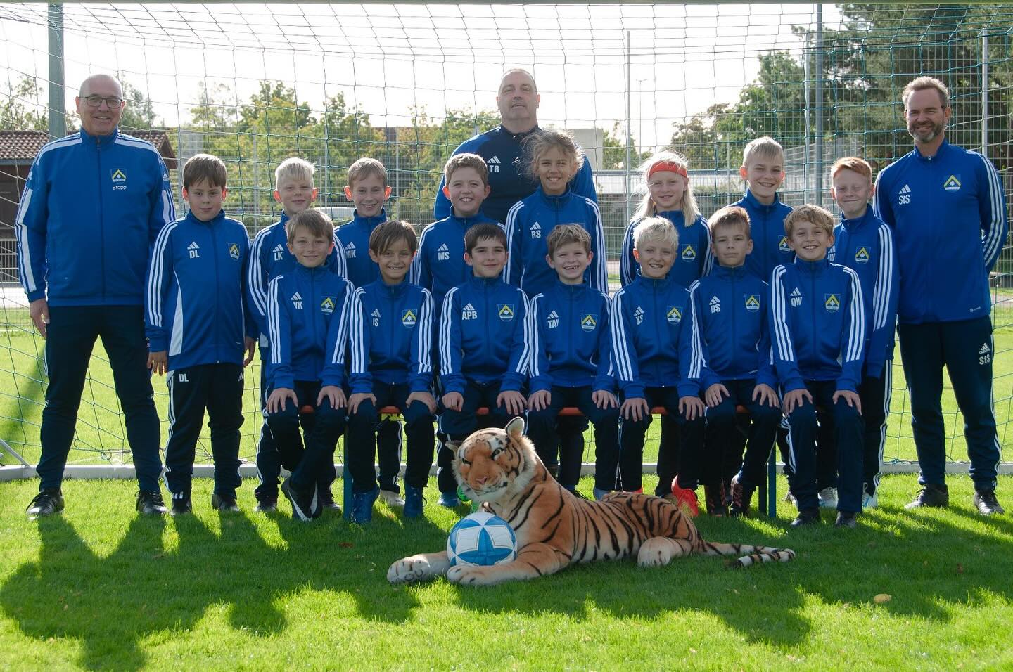 Schreibwaren Lo Feudo sponsert Trainings-Outfit für die U10/2
Die Spielerinnen und Spieler der U10/2, die “Tiger”, freuen sich über ihre neuen Trainingsanzüge, die von Schreibwaren Lo Feudo gesponsert wurden. Das in Aschheim ansässige Fachgeschäft bietet nicht nur ein breites Sortiment an Schul- und Bürobedarf, sondern deckt mit einem gut sortierten Online-Shop auch alles von IT-/Multimedia über Künstler- und Gastronomiebedarf ab. Inhaber Lo Feudo, selbst lange aktiver Fußballer und begeisterter Fußballfan, hat das Team sofort gerne unterstützt. Mit dem einheitlichen Trainingsoutfit können sich die Kinder nun nicht nur sportlich, sondern auch optisch als echte Mannschaft präsentieren.
Die Tiger und das Trainerteam bedanken sich herzlich für dieses Engagement.🔵🟡