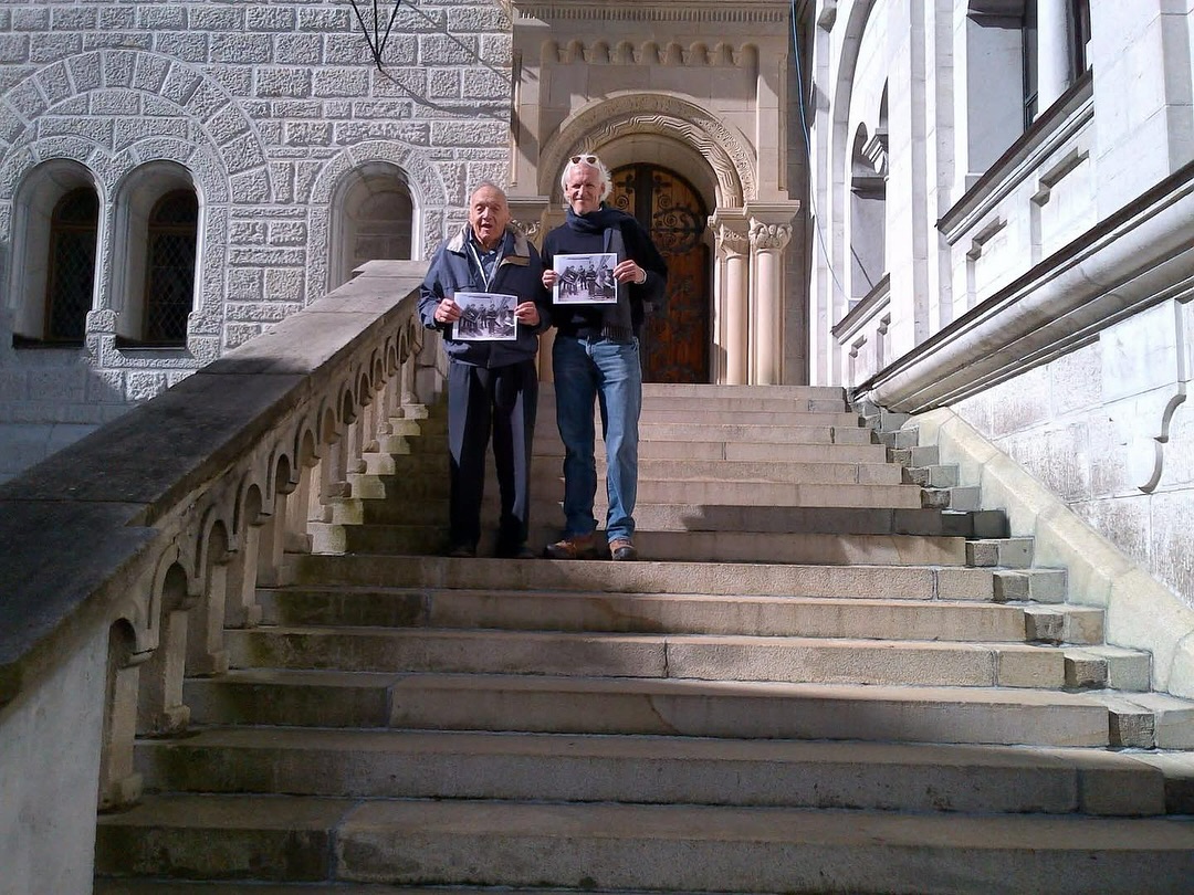 On this day in 2012, I had the extraordinary honor of standing on the steps of Neuschwanstein Castle during The National WWII Museum’s In the Footsteps of the Monuments Men tour. Beside me was Monuments Man Harry Ettlinger, who decades earlier had served under Capt. James Rorimer. Together, Harry and I tried to recreate the famous photo from the cover my book, The Monuments Men—this time with Harry standing in for his former boss. It remains one of the most memorable experiences of my life.
Neuschwanstein was once a Nazi repository for thousands of works of looted art. Thanks to the courage and dedication of the Monuments Men, these cultural treasures were safeguarded and returned to their rightful owners. Today, it’s not only a UNESCO World Heritage Site but also a place that has captured imaginations around the world—even serving as the inspiration for Disney’s Sleeping Beauty Castle.
Just the other day, my son Rodney reminded me of that moment when he pointed out the jigsaw puzzle of Neuschwanstein hanging in his room. It’s amazing how these stories keep connecting generations in unexpected ways!