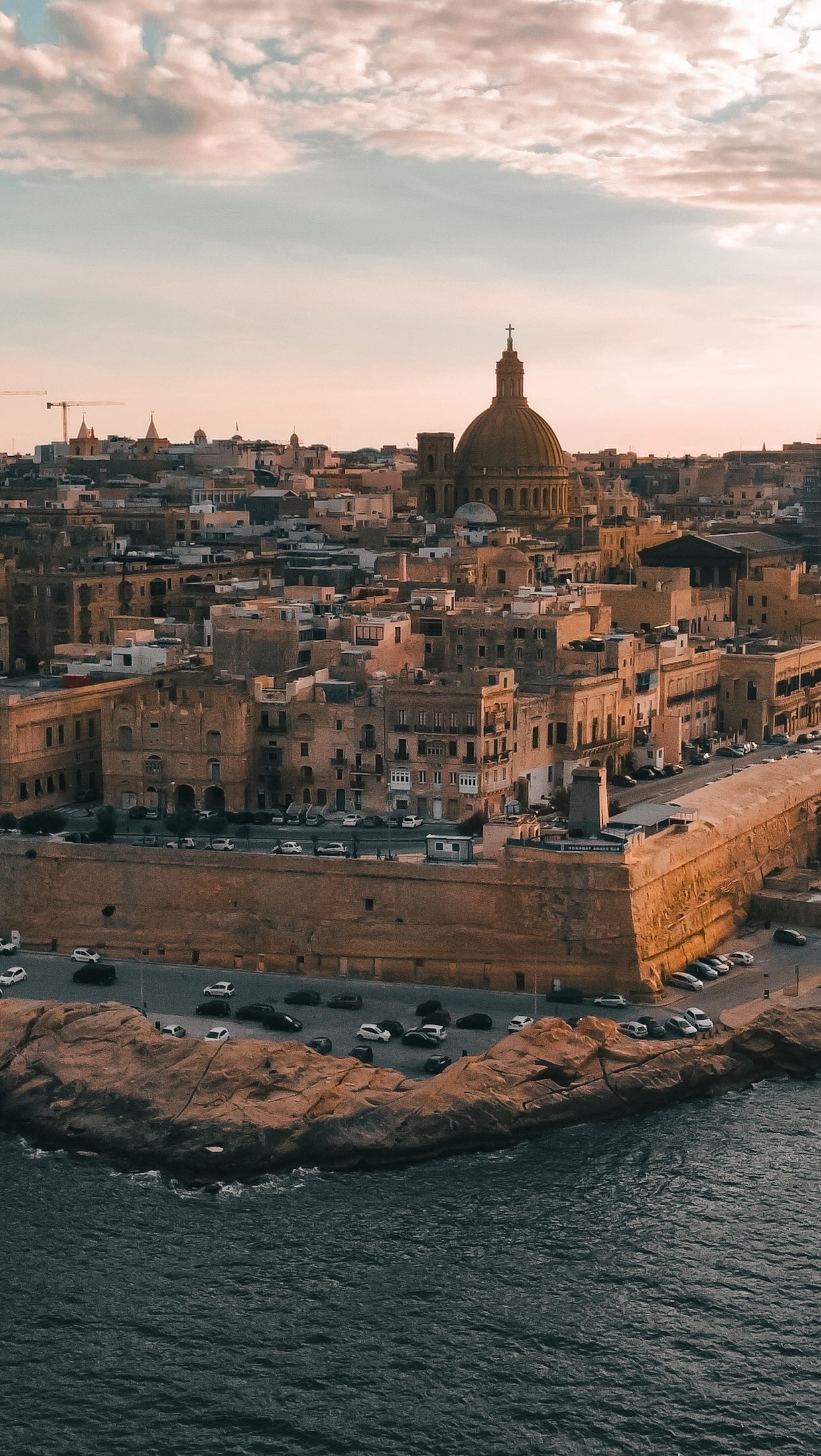 Valletta ist klein, aber sie hat eine Geschichte, die größer ist als viele Metropolen. Die Stadt wurde im 16. Jahrhundert von den Rittern des Johanniterordens gegründet und steht heute auf der UNESCO Welterbeliste. Wenn Ihr durch die Straßen geht, seht Ihr goldgelbe Kalksteinfassaden, verzierte Holzbalkone und Paläste, die an vergangene Zeiten erinnern.
Alles lässt sich zu Fuß erkunden. Beginnt am Grand Harbour mit dem Blick über die mächtigen Festungsmauern. Schlendert weiter durch die Republic Street und Merchant Street, schaut in Boutiquen und kleine Cafés, besucht die St. John’s Co Cathedral mit ihrem beeindruckenden Barockinterieur und nehmt Euch Zeit für die Upper Barrakka Gardens mit Aussicht über den Hafen.
Valletta ist tagsüber ruhig und geschichtsträchtig, abends aber lebendig. Musik aus Bars und Restaurants erfüllt die Gassen, Menschen sitzen auf Treppenstufen und genießen den Blick aufs Meer. Die Hauptstadt von Malta ist perfekt für einen Citytrip, wenn Ihr Kultur, Geschichte und mediterranes Flair mögt.
#valletta #malta #visitmalta #citytrip #maltaislands @visitmalta @LoveMalta