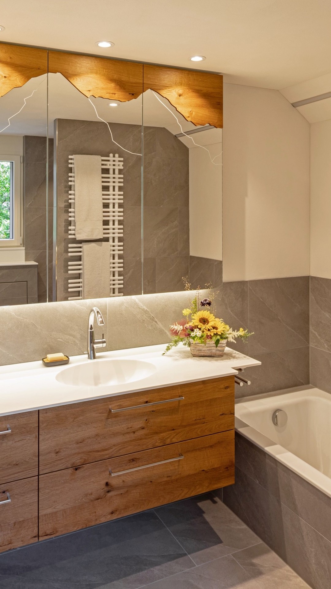 Der Spiegel, der die Bergwelt ins Badezimmer holt, ist ein richtiger Blickfang.
Dazu eine Küche in frischem Grün, das Leichtigkeit und Energie ausstrahlt.
So entsteht Wohnraum, der Charakter zeigt und Freude macht.