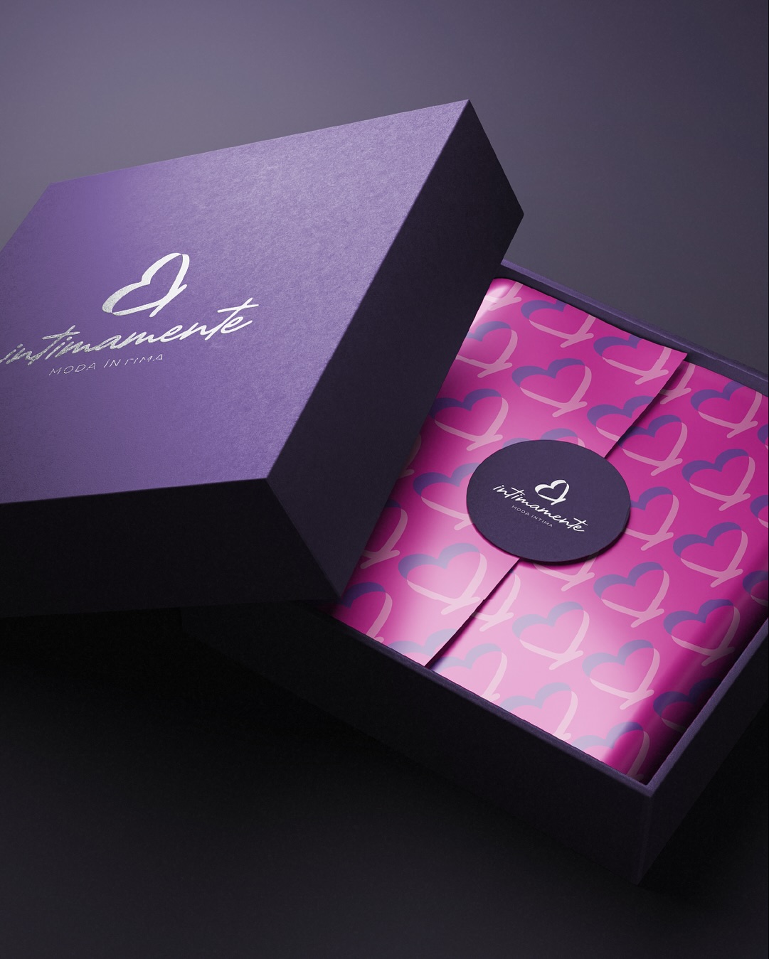 Criamos a identidade da Intimamente para traduzir um posicionamento claro: personalização que gera resultado.
O símbolo nasce da combinação entre coração, borboleta e as iniciais, criando um ícone que comunica simultaneamente feminilidade, movimento e vínculo emocional. As formas sobrepostas sugerem camadas, uma metáfora visual para a experiência personalizada que a marca oferece.
Pensamos o visual para preservar a legibilidade e o impacto em qualquer formato, seja estampas de embalagem, layouts para campanhas digitais e peças impressas.
