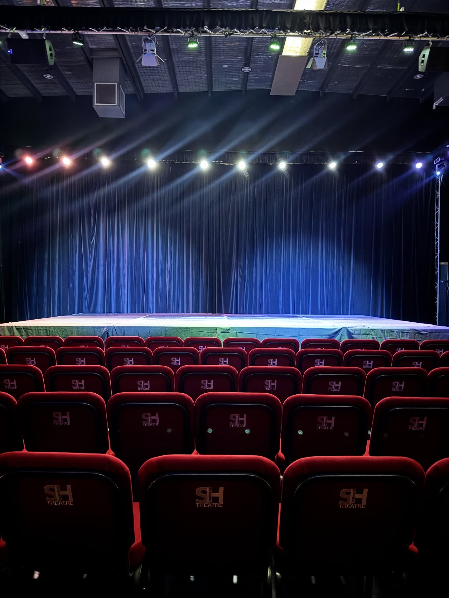 StageHouse Theatre – A True Chameleon
StageHouse Theatre is a versatile, multi-purpose venue that adapts seamlessly to your artistic vision. With a 16m x 16m performance space, the theatre can be configured in a range of ways to suit productions of all sizes.
* Traditional Performance Stage – choose between a flat floor or raised staging option, complete with curtains, wings, and full lighting/sound rigging for theatre, dance, and music.
* Runway & Fashion Shows – extended stage and seating layouts designed to showcase designers and performers.
* Q&A / Conference Setup – reconfigured seating banks and staging for panels, forums, and presentations.
* Immersive & Flexible Productions – open floor or custom-built layouts for contemporary works, site-specific pieces, or creative showcases.
* Dance Studio Mode – the space can be converted into a fully equipped studio with sprung floor, mirrors across four lengths, and professional sound, perfect for rehearsals, workshops, and classes.
*
Seating capacity ranges from 120 to 300, allowing the theatre to transform from a full stage production to an intimate performance setting.
Our StageHouse team builds to your needs, ensuring every event is supported with the right configuration, atmosphere, and technical expertise.