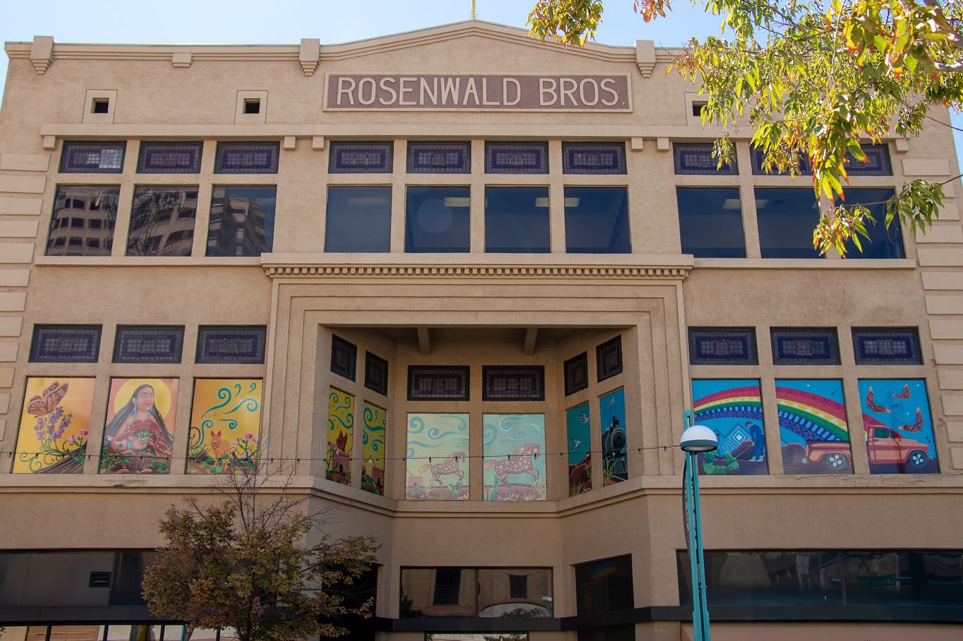 This year, I was among the artists who contributed to a public art installation celebrating the 100th anniversary of Route 66. I got the Rosenwald Building, located in downtown Albuquerque, New Mexico, the only place in the country where the original road intersects with the newer route.
Inspired by downtown Albuquerque's cruising culture, the land, and the local communities that are rooted here, I created a vinyl mural that surrounds the building's windows. It tells a story of how Mother Earth crafted a road connecting communities through travel and culture from the dawn of time into the future.