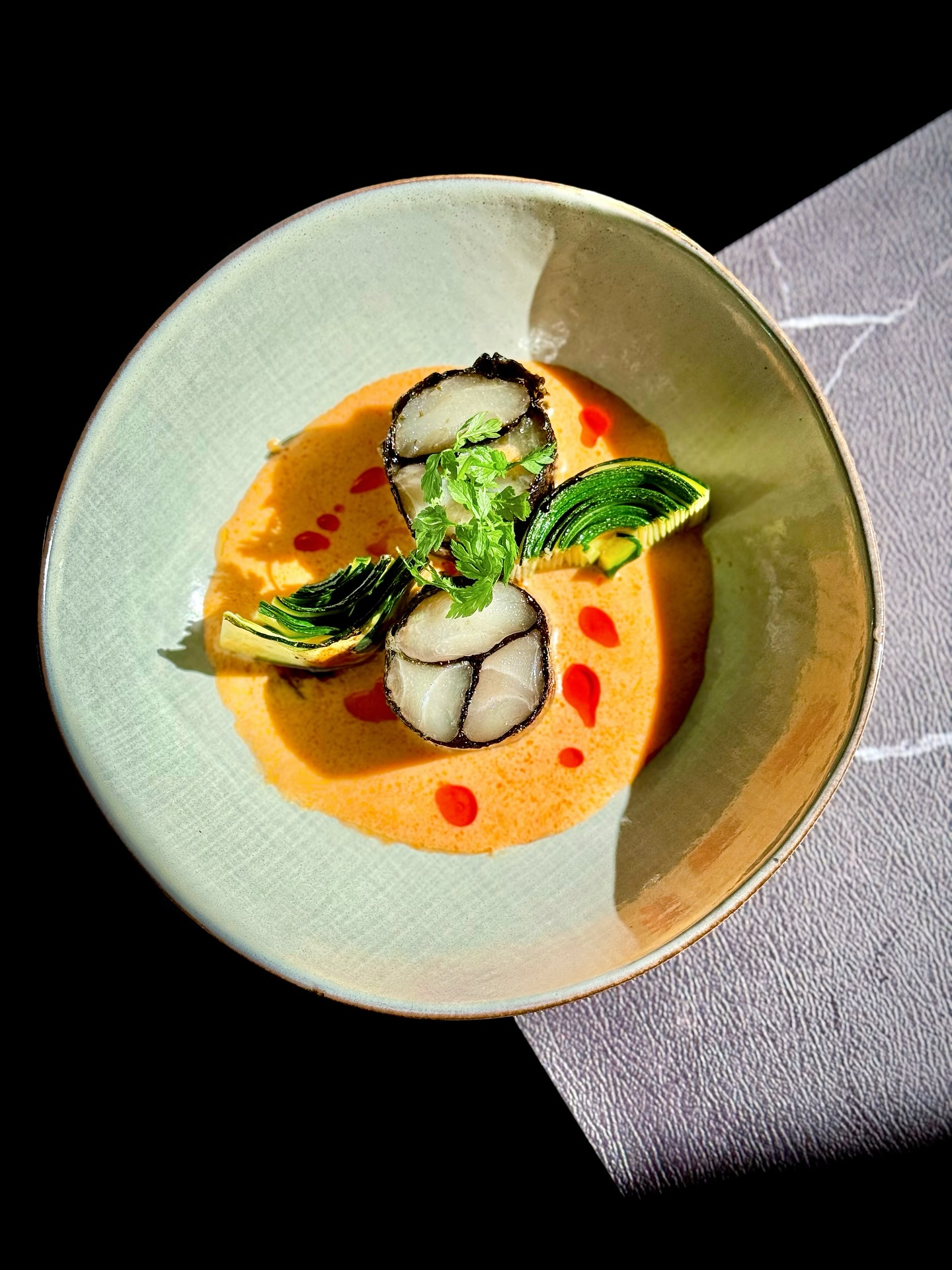 Menu du Midi
🇫🇷 【SILENCE DES FONDS CLAIRS | 澄光无声】🐟🌶️
Un plat alliant l’élégance du cabillaud enrobé d’algue nori formant un motif marbré, à la richesse d’une sauce au piment chinois légèrement épicée. La douceur du poisson contraste avec la vivacité du piment et la fraîcheur de la courgette — une rencontre poétique entre la mer et la terre, à la manière chinoise contemporaine.
这道菜将细腻的鳕鱼裹上海苔,卷成大理石花纹,视觉与味觉兼具艺术感。配以微辣的乳化烧椒酱,带出独特的中式烟火气,与翠绿的西葫芦交织出一场味觉的山海对话。香、辣、鲜、柔并存,是东方风味的现代演绎。
🇫🇷 Sauce au piment grillé émulsionnée 🌶️🍶
Cette sauce est une création moderne inspirée de la tradition chinoise du “shao jiao” — le piment rôti au feu vif. Les piments sont d’abord grillés jusqu’à obtenir un arôme fumé et profond, puis pelés et écrasés. On les mélange ensuite avec un bouillon, de l’huile (d’arachide ou d’olive) et parfois une touche lactée, avant d’émulsionner le tout pour obtenir une texture onctueuse et homogène.
Le résultat est une sauce à la fois fumée, légèrement piquante et veloutée, qui marie l’intensité du feu à la douceur de l’émulsion. Parfaite pour accompagner poissons, viandes blanches ou légumes — un pont subtil entre la tradition chinoise et la gastronomie moderne.
🇨🇳 乳化烧椒酱 🔥🥣
乳化烧椒酱是一种将传统烧椒风味与现代烹饪技法融合的中式酱汁。“烧椒”指的是将青椒或辣椒以明火炙烤至表皮焦香,再去皮打碎,保留其烟熏香气与自然辣味。在此基础上,加入高汤、油脂(如花生油或橄榄油)与少量乳制成分,通过乳化工艺(emulsion)让油水充分融合,形成质地细腻、味道圆润的酱汁。
这种酱汁既保留了中式烧椒的火候香气,又拥有西式酱汁的丝滑与层次感,非常适合搭配海鲜、白肉或蔬菜,带来“烟火与细腻并存”的东方味觉体验。
📖 Réservation: www.bistrowu.com
#CuisineChinoiseModerne #CabillaudMarbré #SaveursOrientales #GastronomieFusion #artculinaire #SauceChinoise #PimentGrillé #ÉmulsionOrientale #cuisinefusion #aix #aixmaville #aixenprovence #aixenpce #aixmarseille